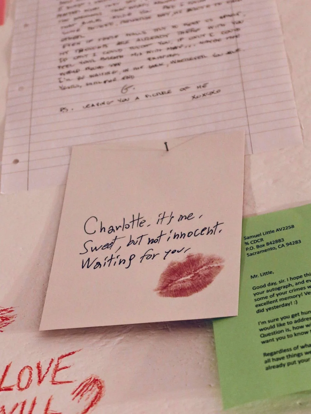 Dettaglio ravvicinato della documentazione fotografica d'atmosfera: un biglietto scritto a mano con un'impronta di rossetto, parte dell'allestimento espositivo al Bloom Room.