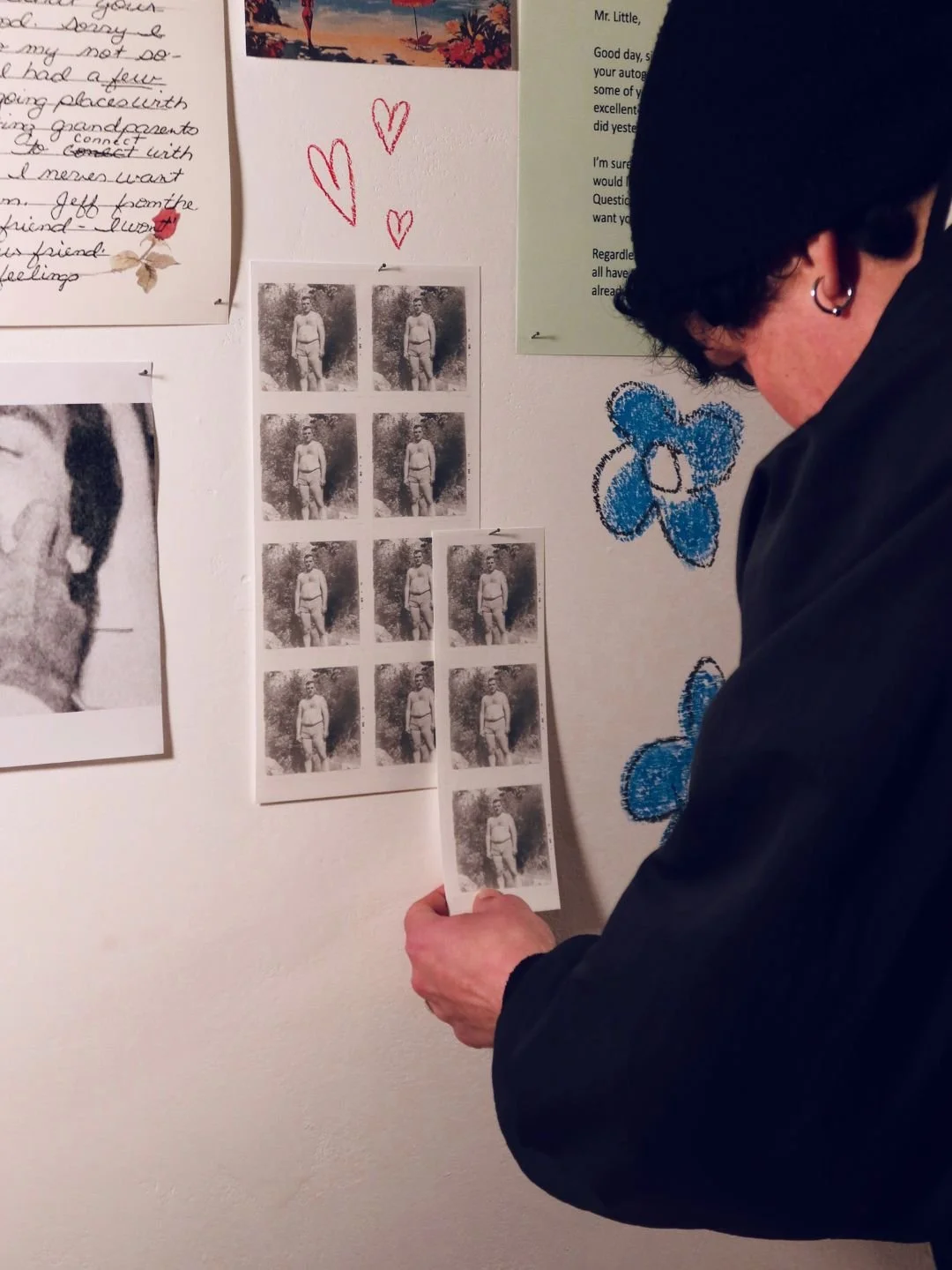 Dettaglio della documentazione visiva per il progetto Hungry Heart @ Bloom Room: una visitatrice analizza una striscia di provini fotografici in bianco e nero durante la mostra.
