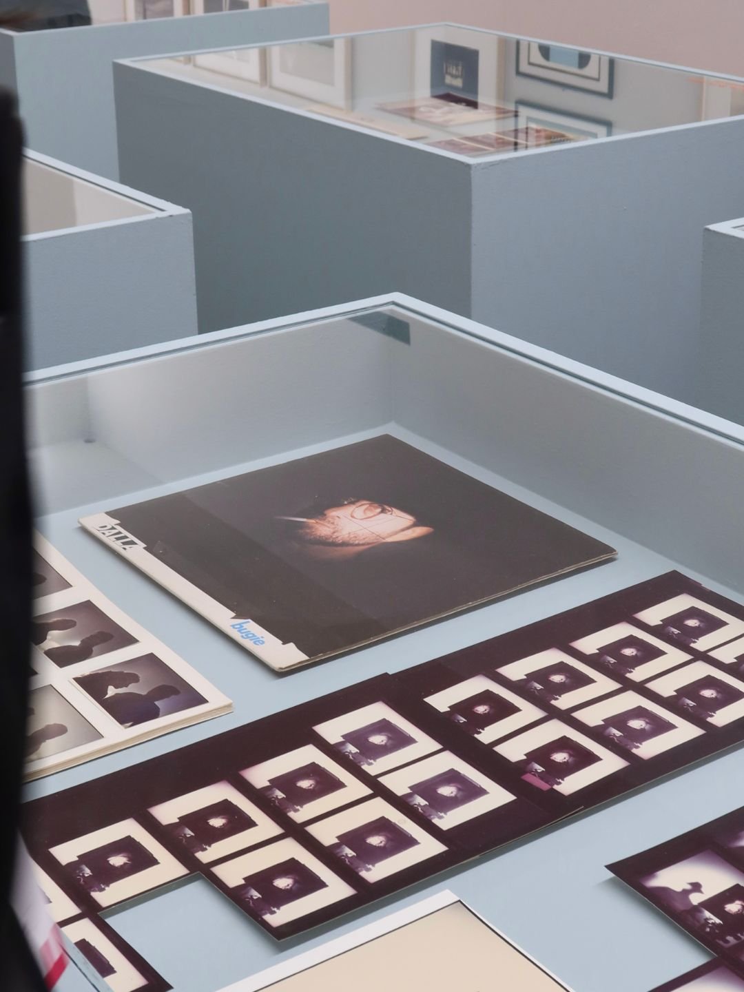 Mostra di fotografie e copertine di album musicali su un tavolo in una galleria o mostra d'arte.