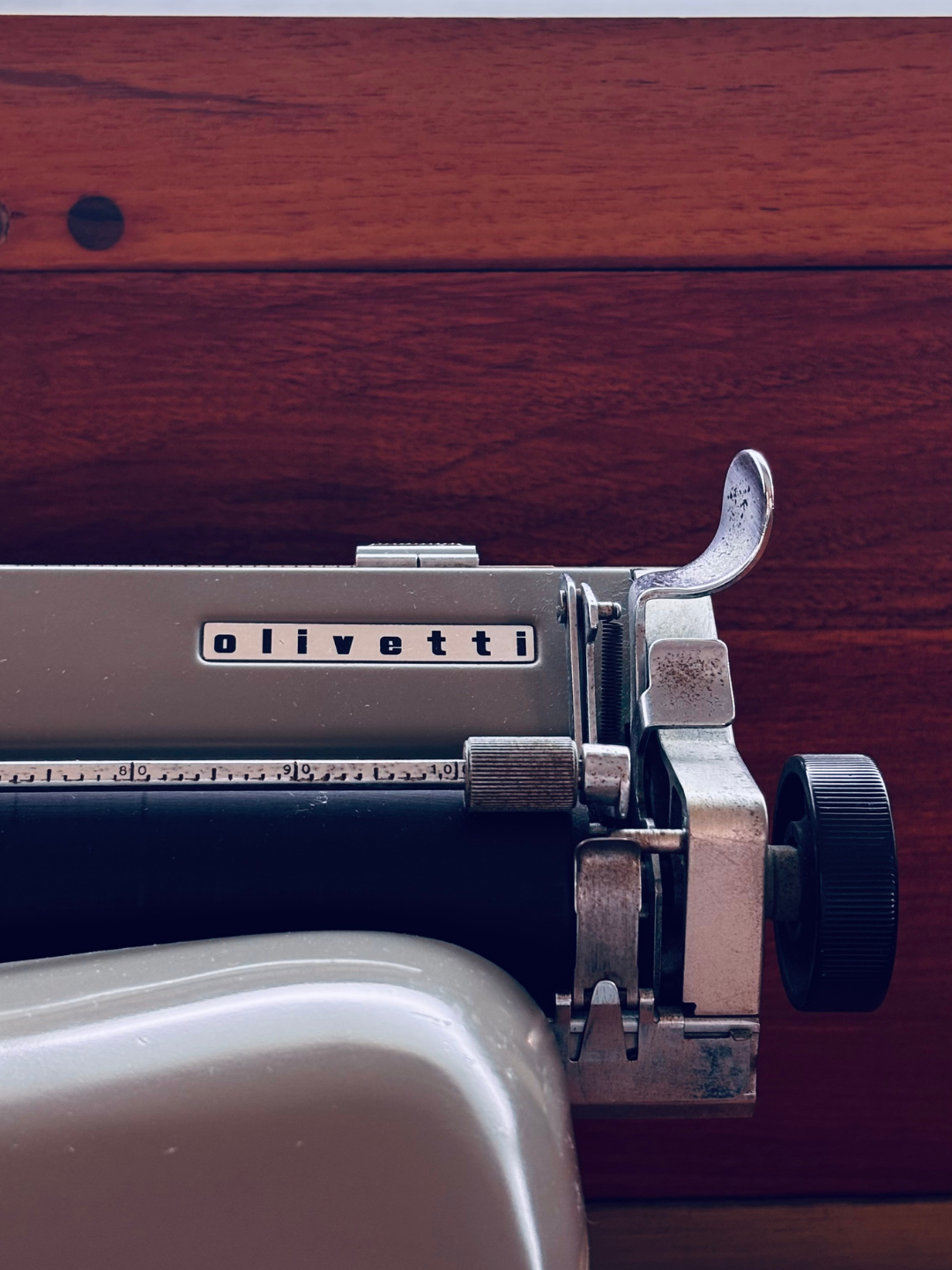 Macchina da scrivere di marca Olivetti su tavolo di legno.