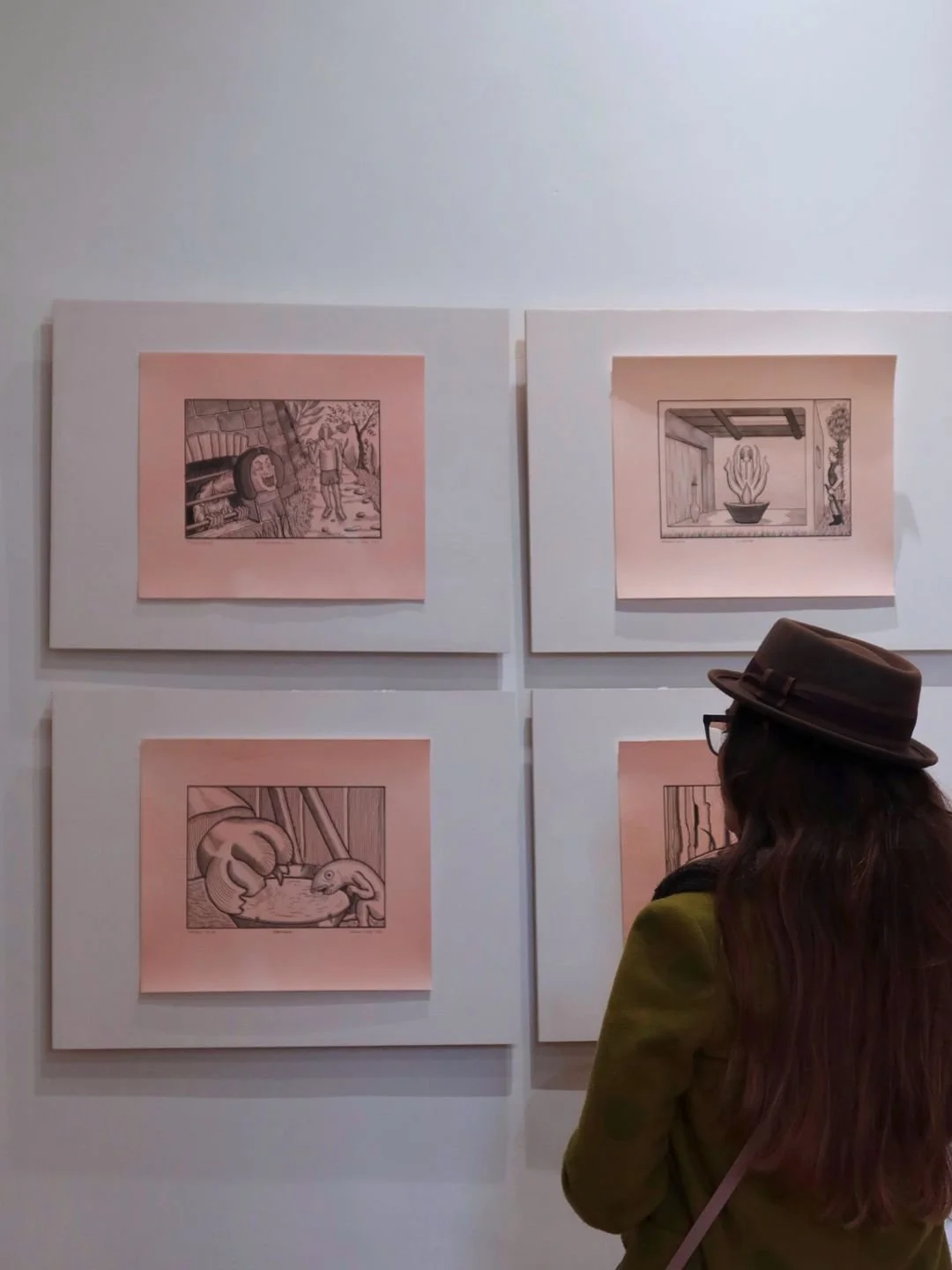Una visitatrice di spalle osserva le opere allestite a parete a Spazio Arrivabene 2. Reportage sul campo e documentazione visiva di eventi espositivi a Mantova.