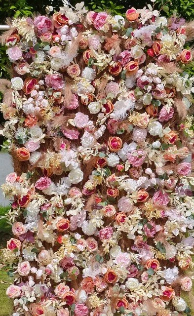 A large floral arrangement with pink, white, and peach roses, along with various other light-colored flowers and greenery.