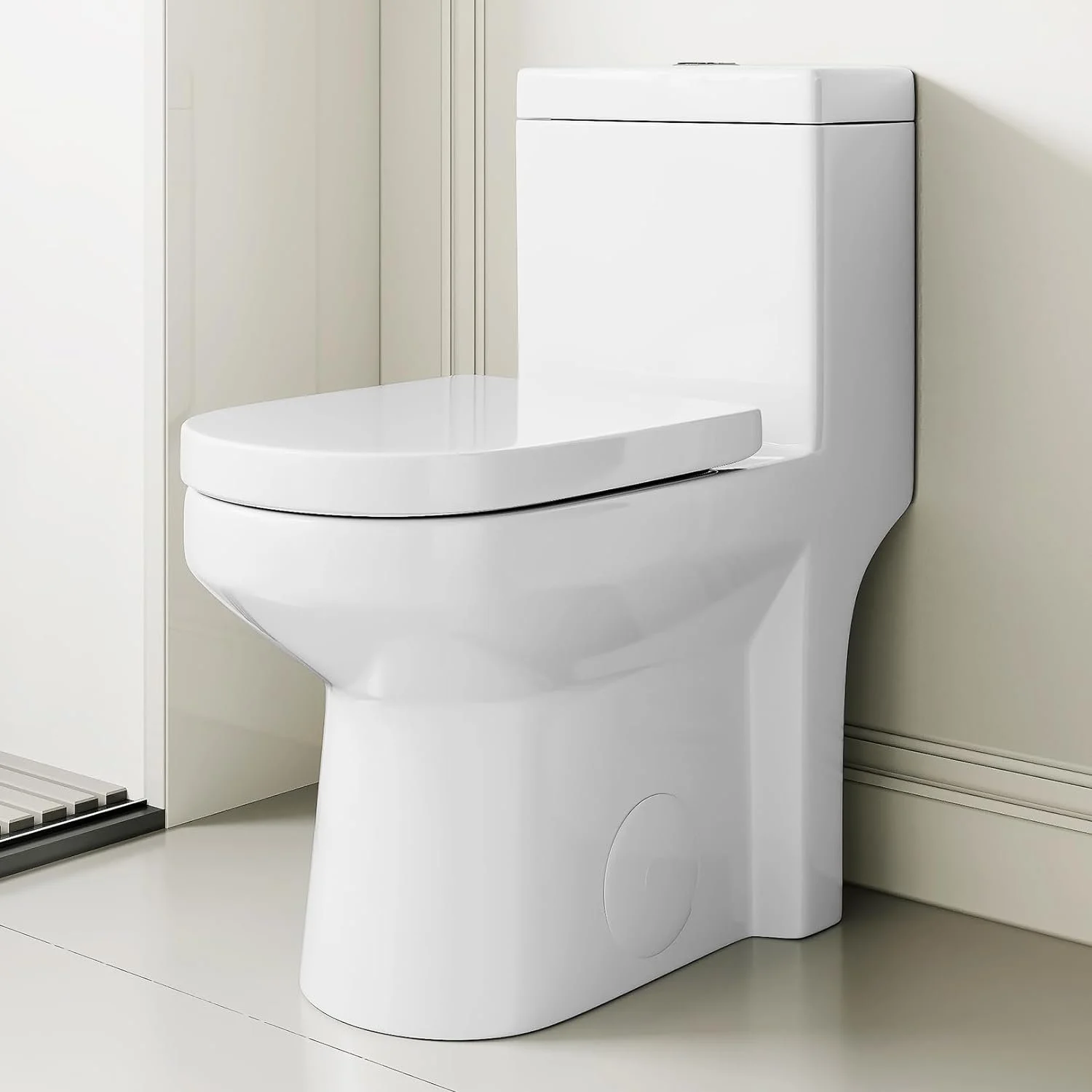 A modern white toilet in a bathroom with beige walls and a small black and white striped rug.