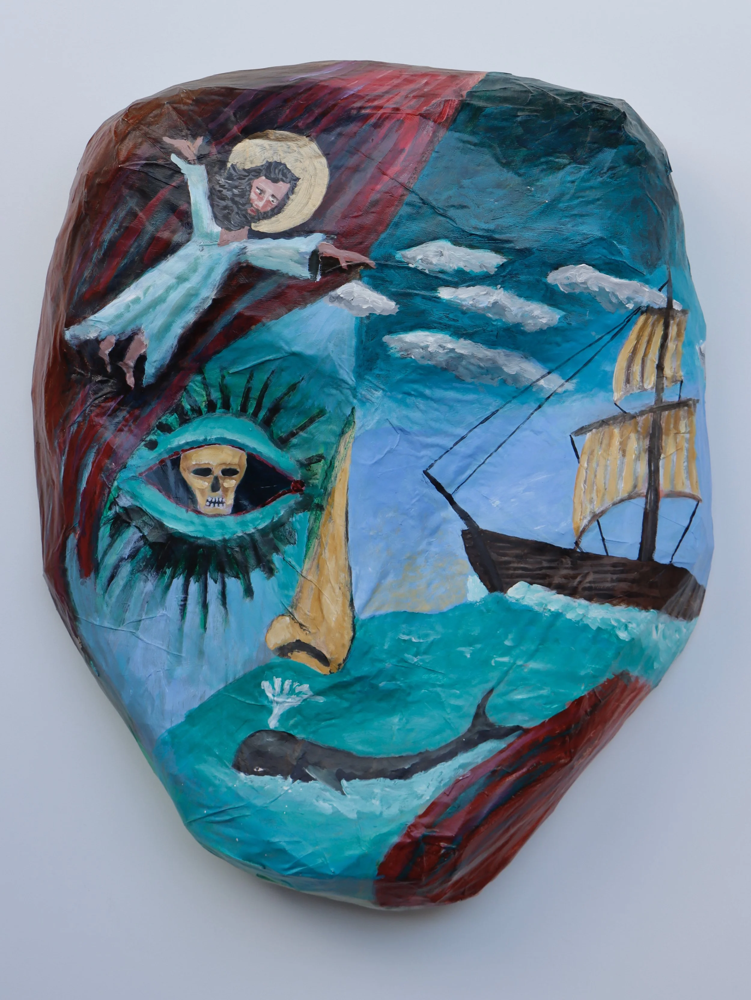 A painted paper lantern featuring a depiction of Jesus Christ with a halo, reaching out towards a ship and a skull, with clouds in the background.