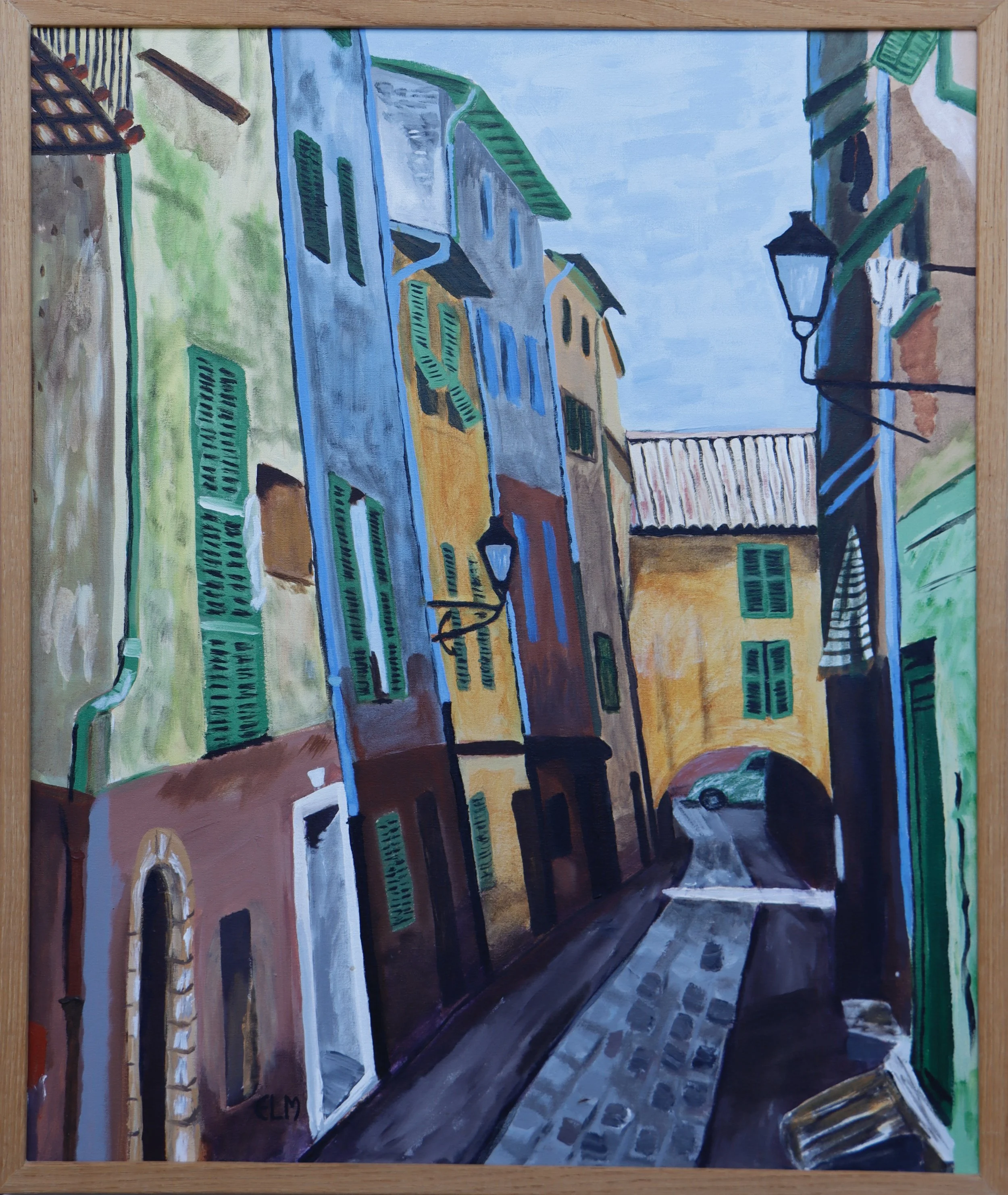 A colorful painting of a street scene with tall buildings, green shutters, a cobblestone pathway, and a parked car. The sky is light blue, and the artwork is framed in light wood.