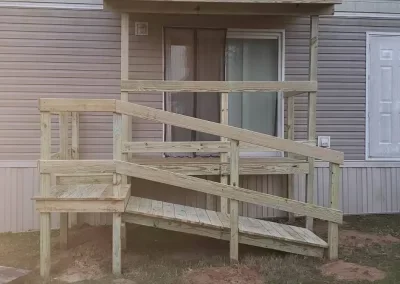 Wooden ramp and deck attached to the back of a house.