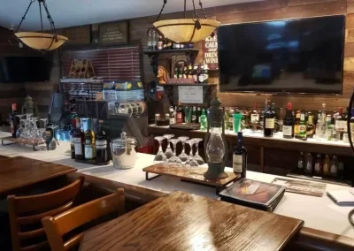Bar counter with liquor bottles and barware in a cozy restaurant or pub
