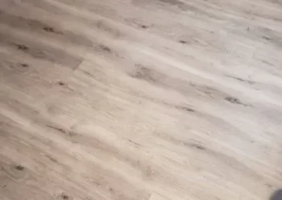 Close-up of a light wood floor with a natural grain pattern.