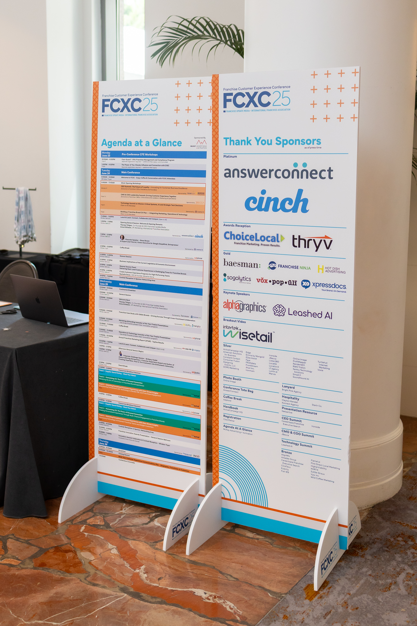 Event schedule and sponsor information boards at the Franchise Customer Experience Conference (FXC).