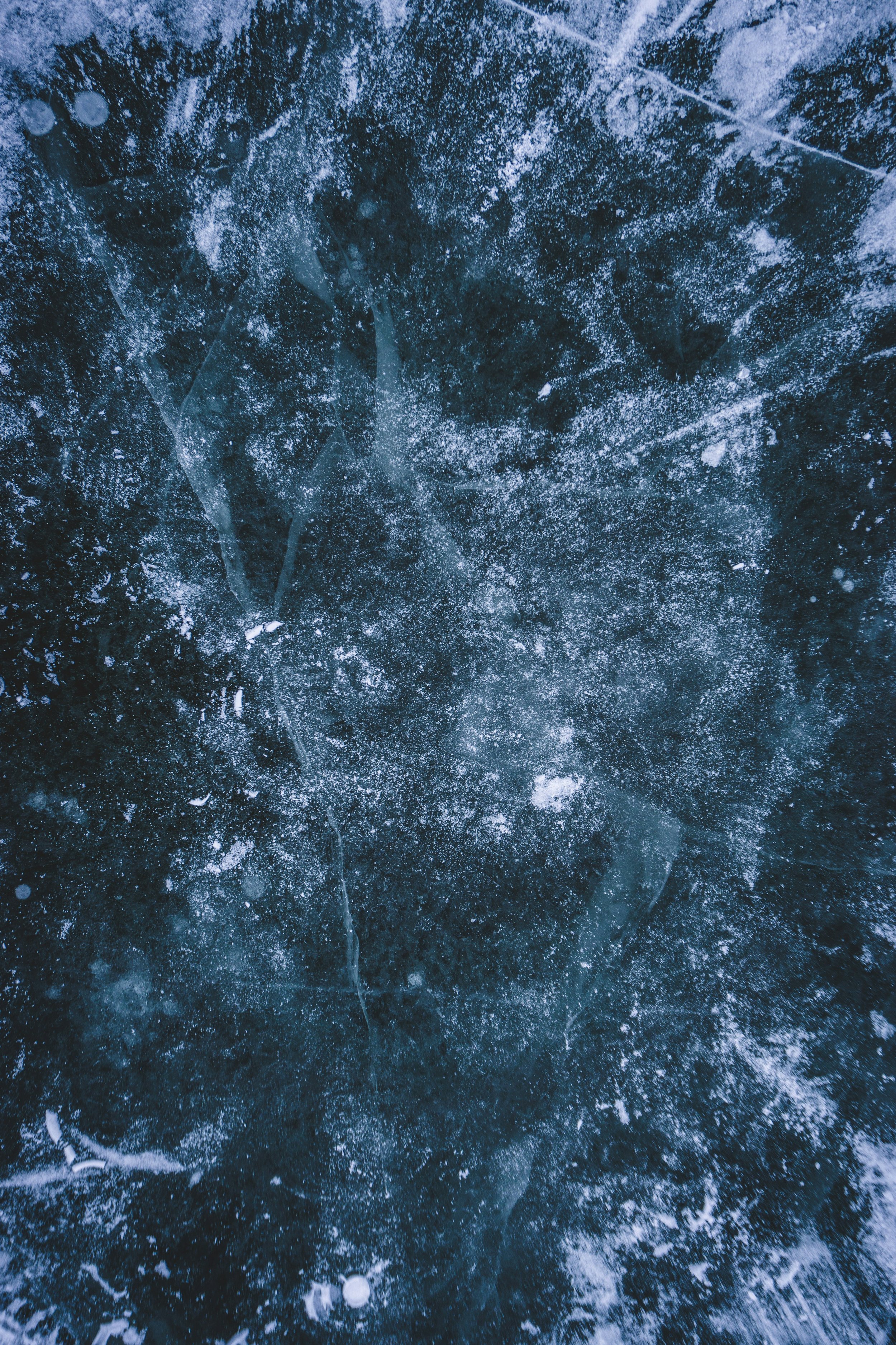 Close-up of ice with snow and cracks on its surface.