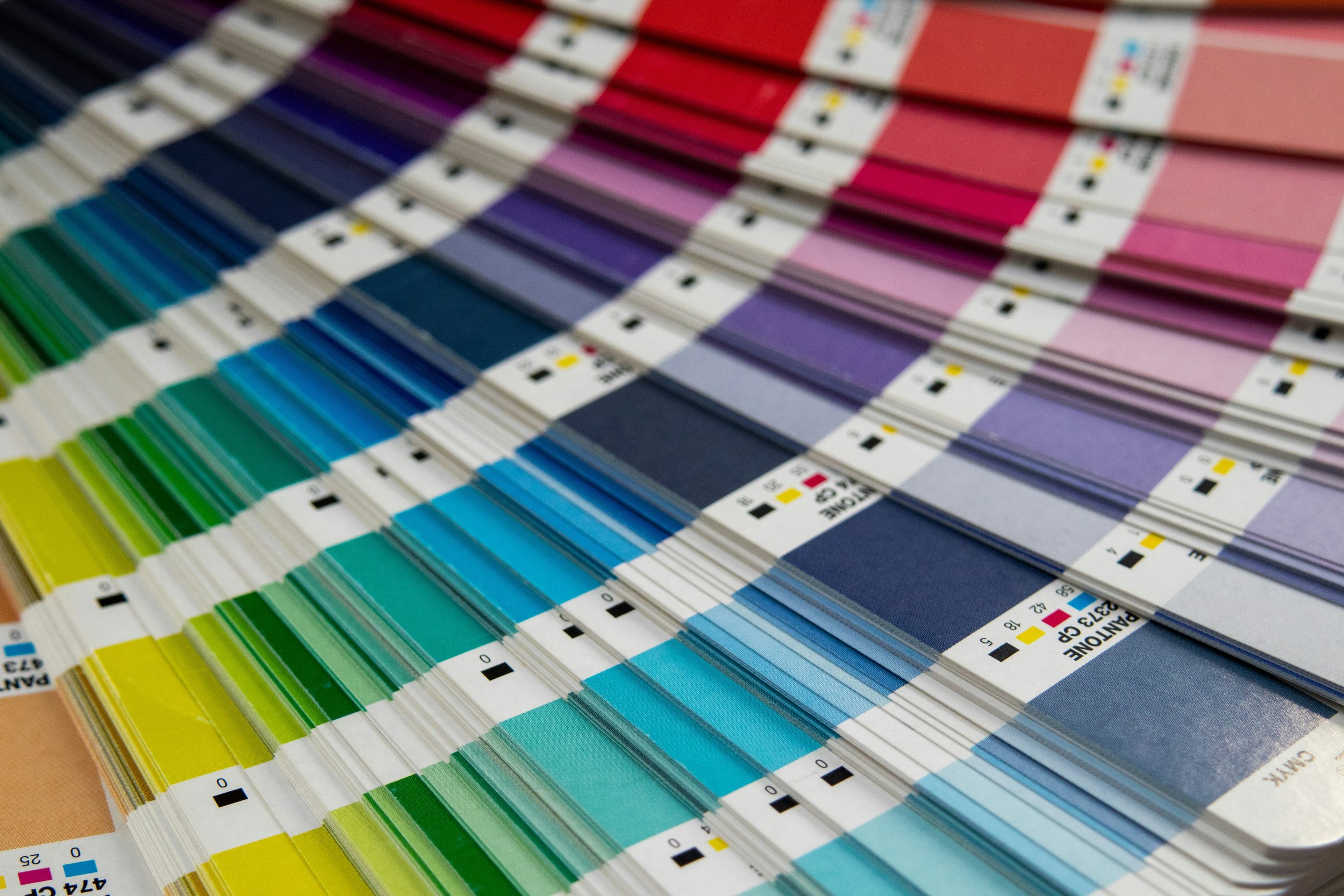 Color swatch sample fan deck with various shades of blue, green, pink, purple, and red.