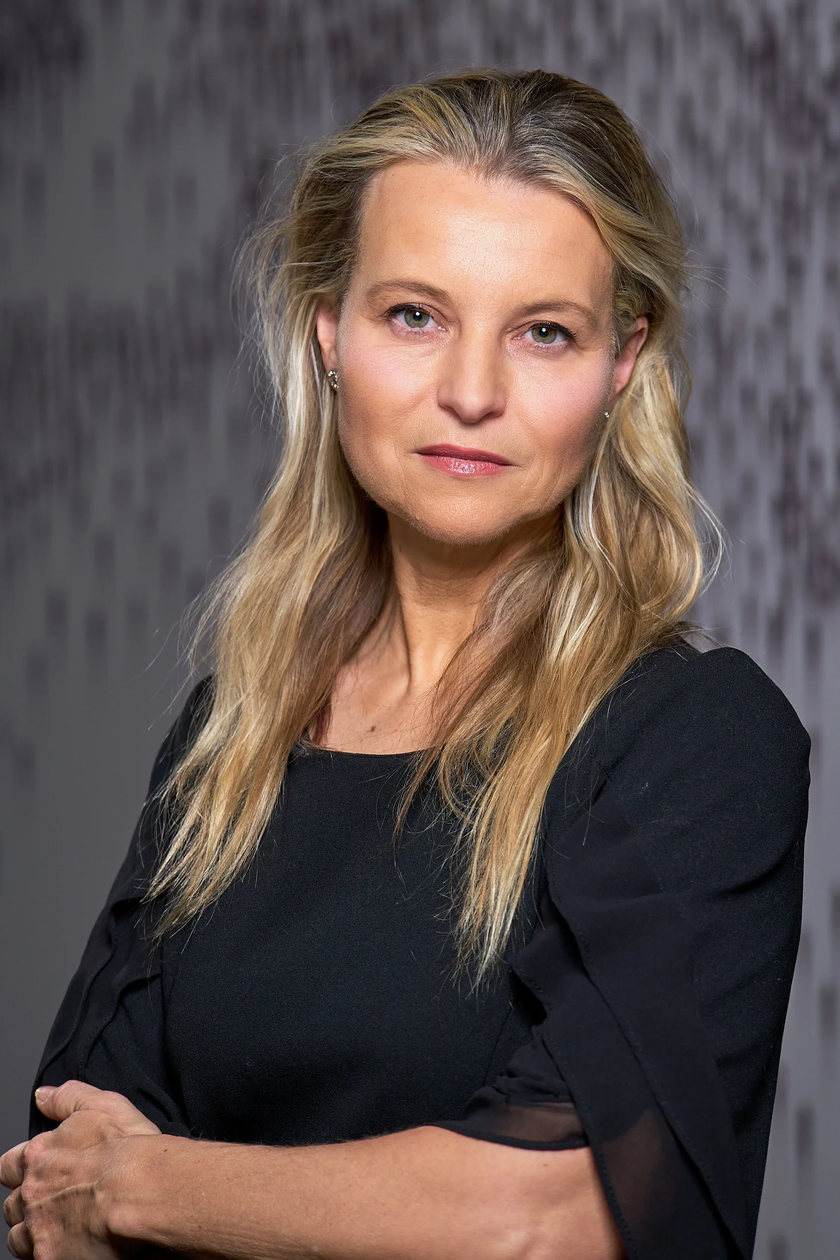 Executive portrait of woman with arms crossed in professional attire by Brooklyn photographer Arsen Vasquez
