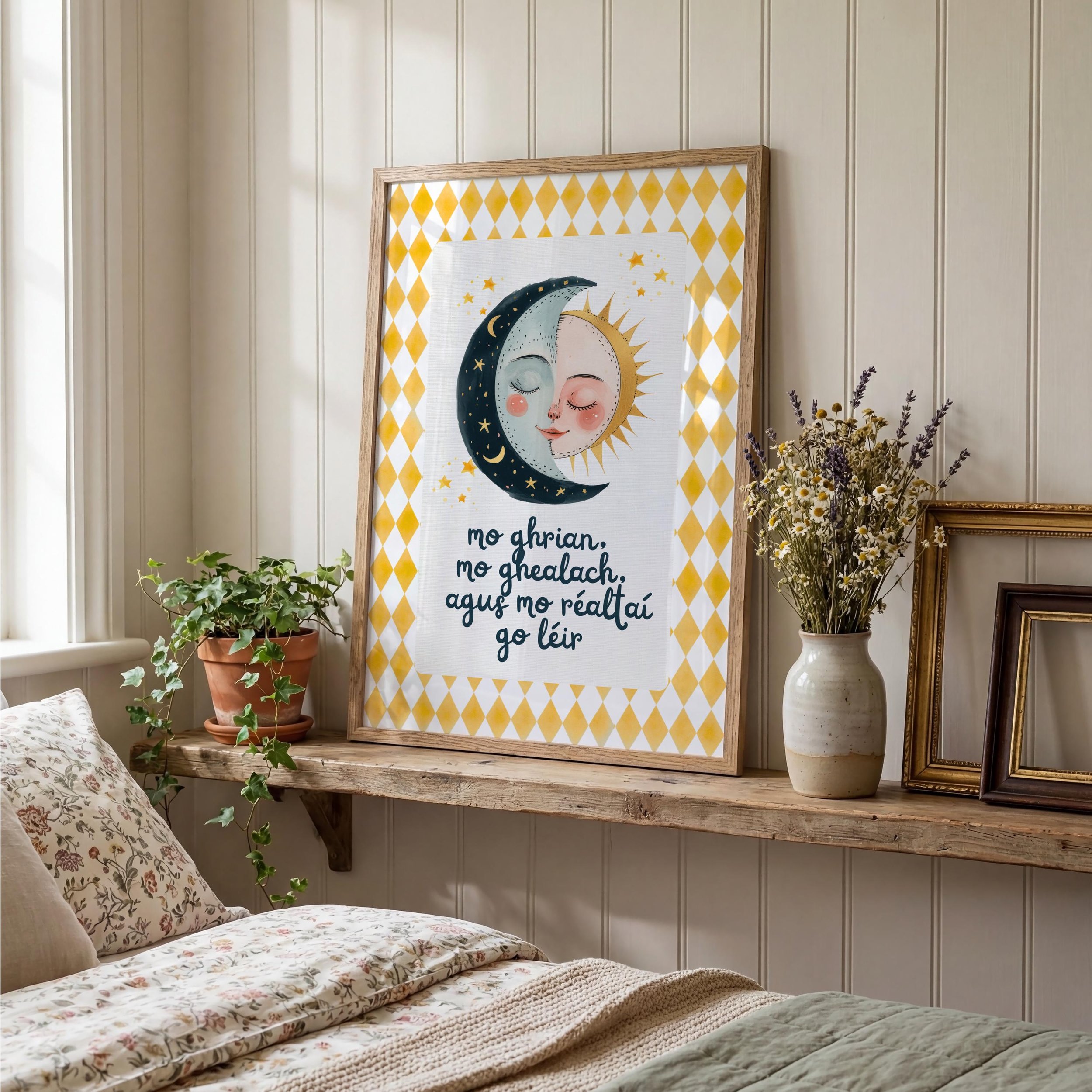 A bedroom corner with floral bedding, a green potted plant on a wooden shelf, and a framed artwork of a smiling sun and moon with stars and a pattern of yellow diamonds on the wall.  Irish Language nursery Print