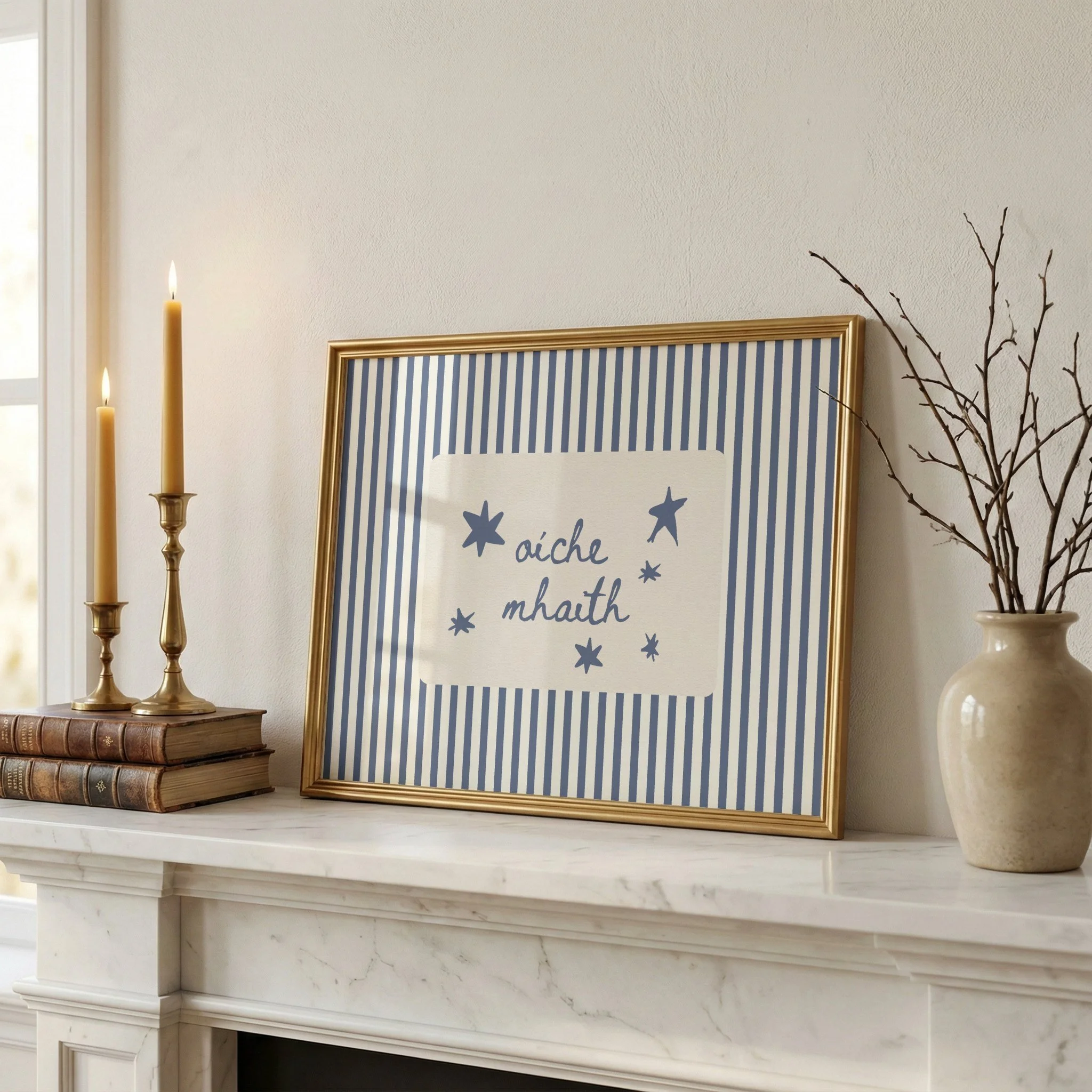 Decorative mantle with a framed star-themed quote, tall ceremonial candles in a holder, a stack of vintage books, and a vase with bare branches.
