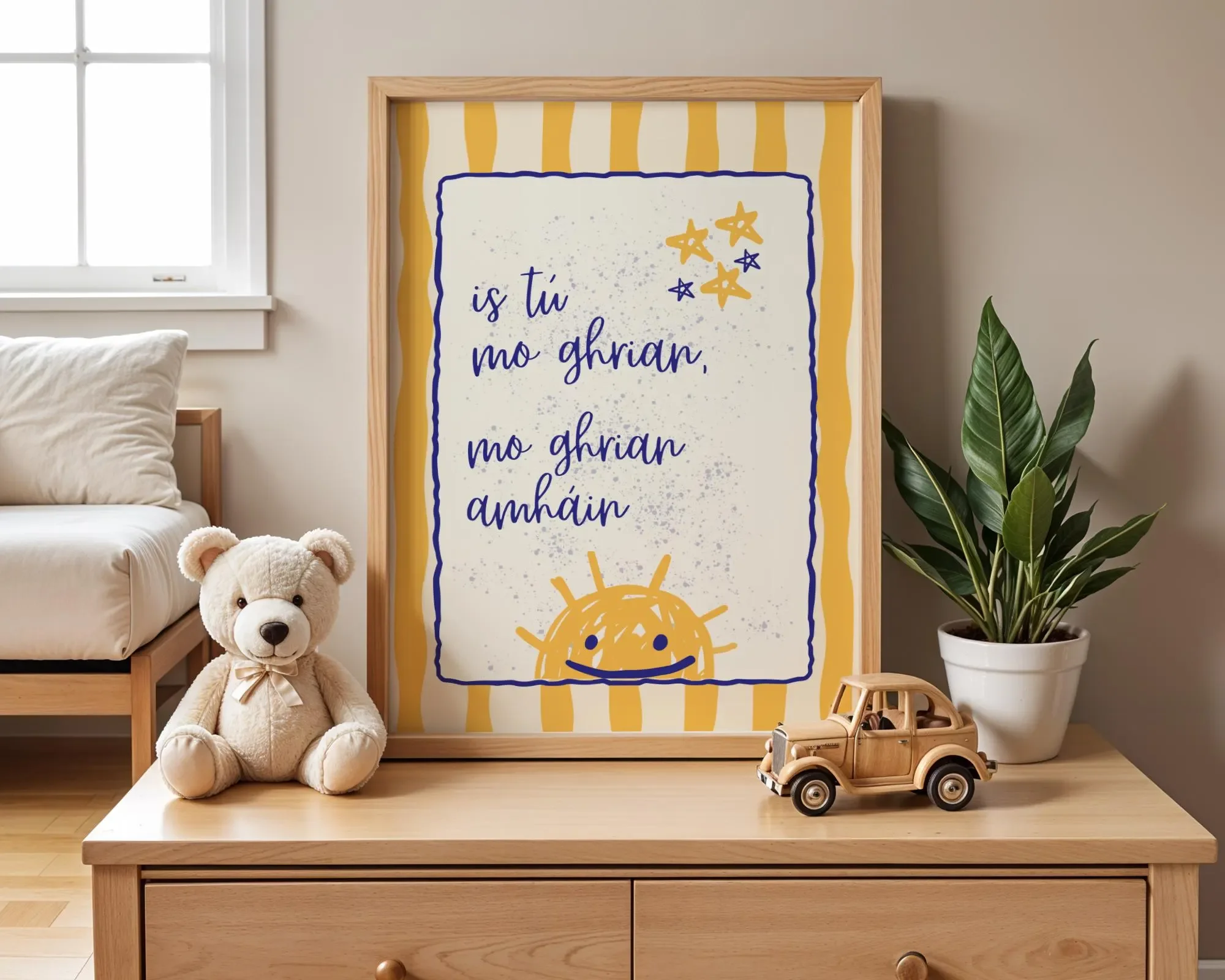 Decorative bedroom wall with a framed print, plush teddy bear on a table, toy wooden car, and potted plant.  Irish Language nursery Print