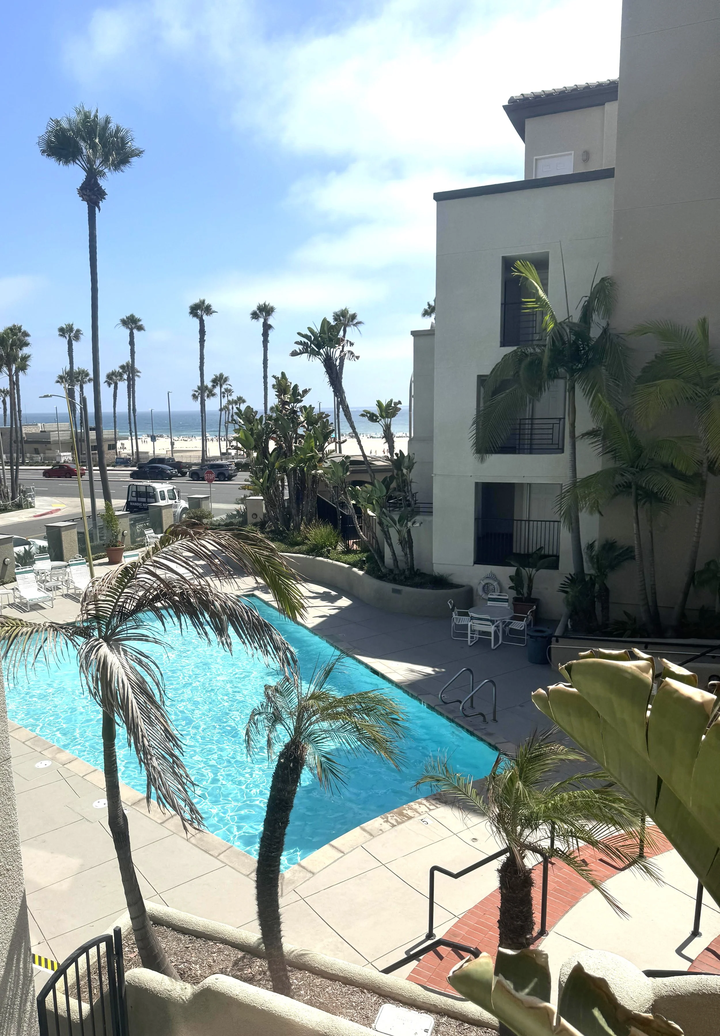 Pier Colony condos for sale in Huntington Beach with the pool and beach in the background.