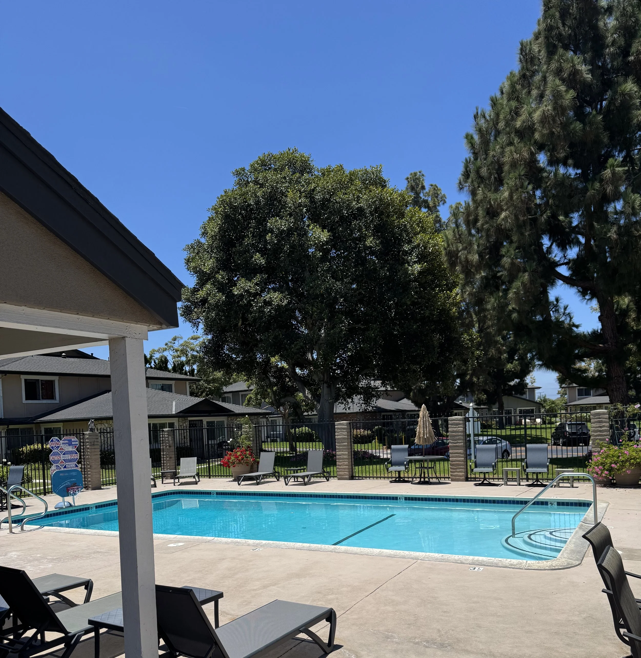 Huntington Gardens townhomes for sale in Huntington Beach featuring the pool with homes in the background.