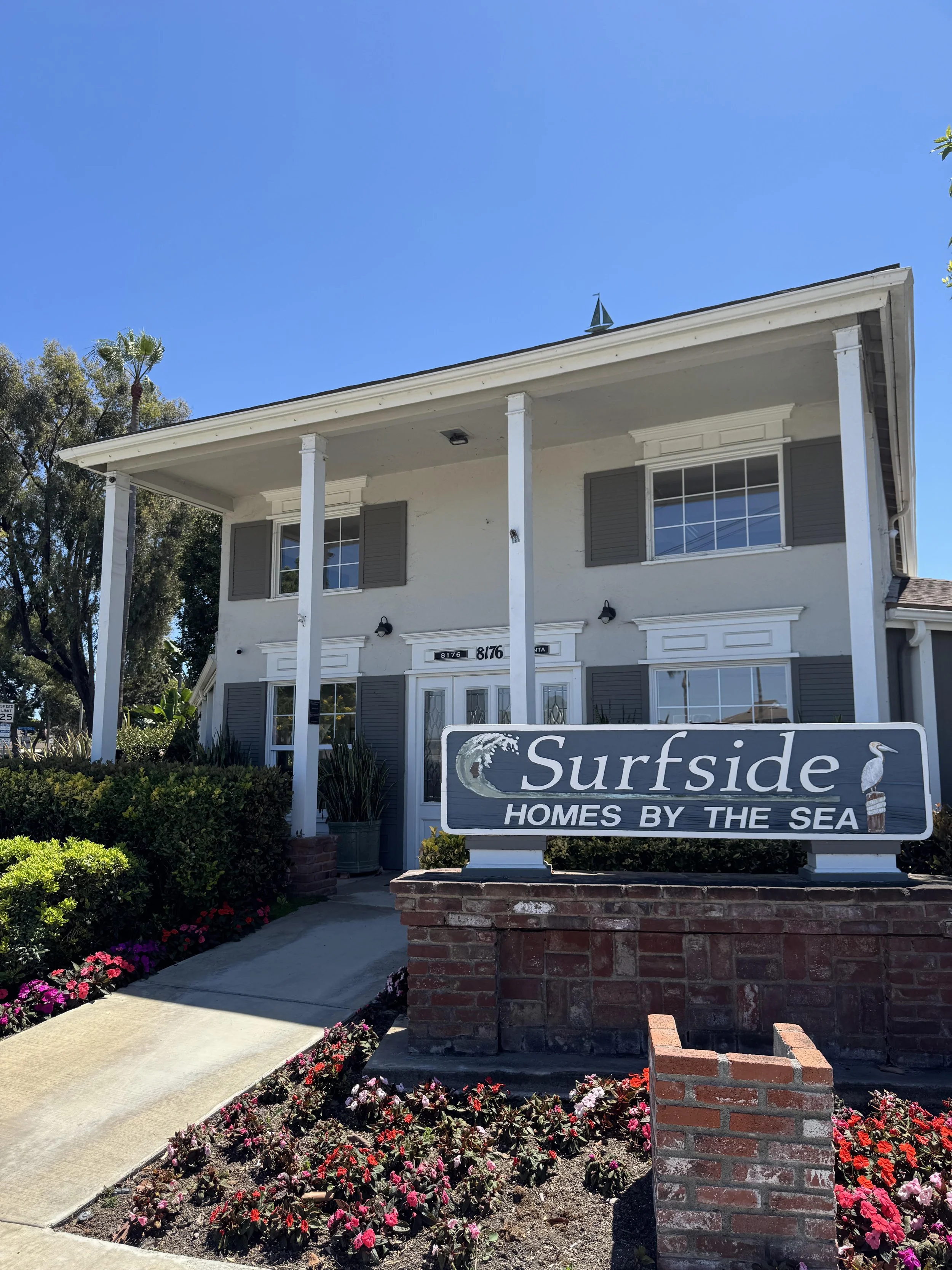 Surfside Homes By The Sea for sale in Huntington Beach featuring the community entrance sign placard and clubhouse.