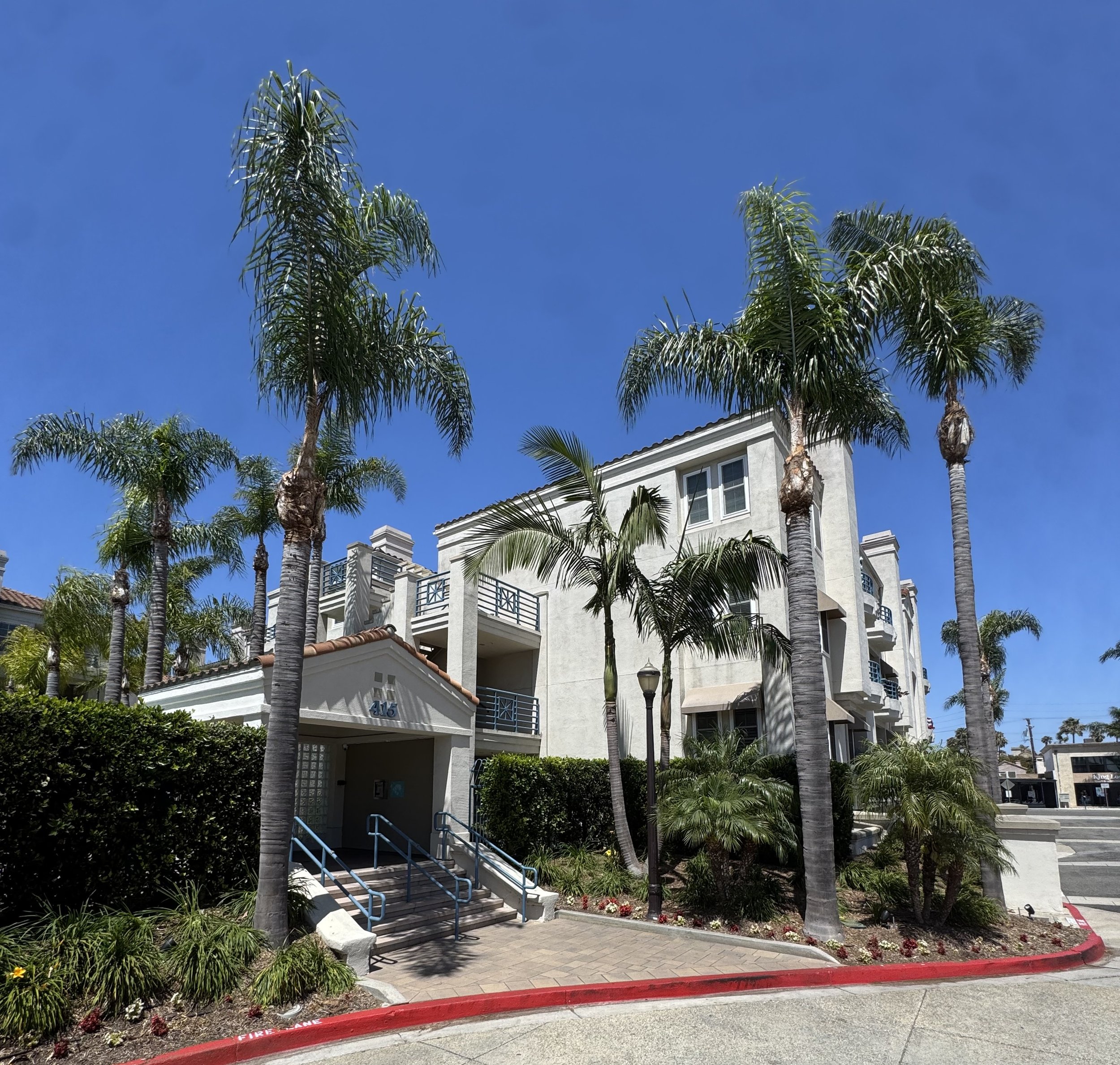 Townsquare condos for sale in Huntington Beach showing the entrance near the pool and building in the background.