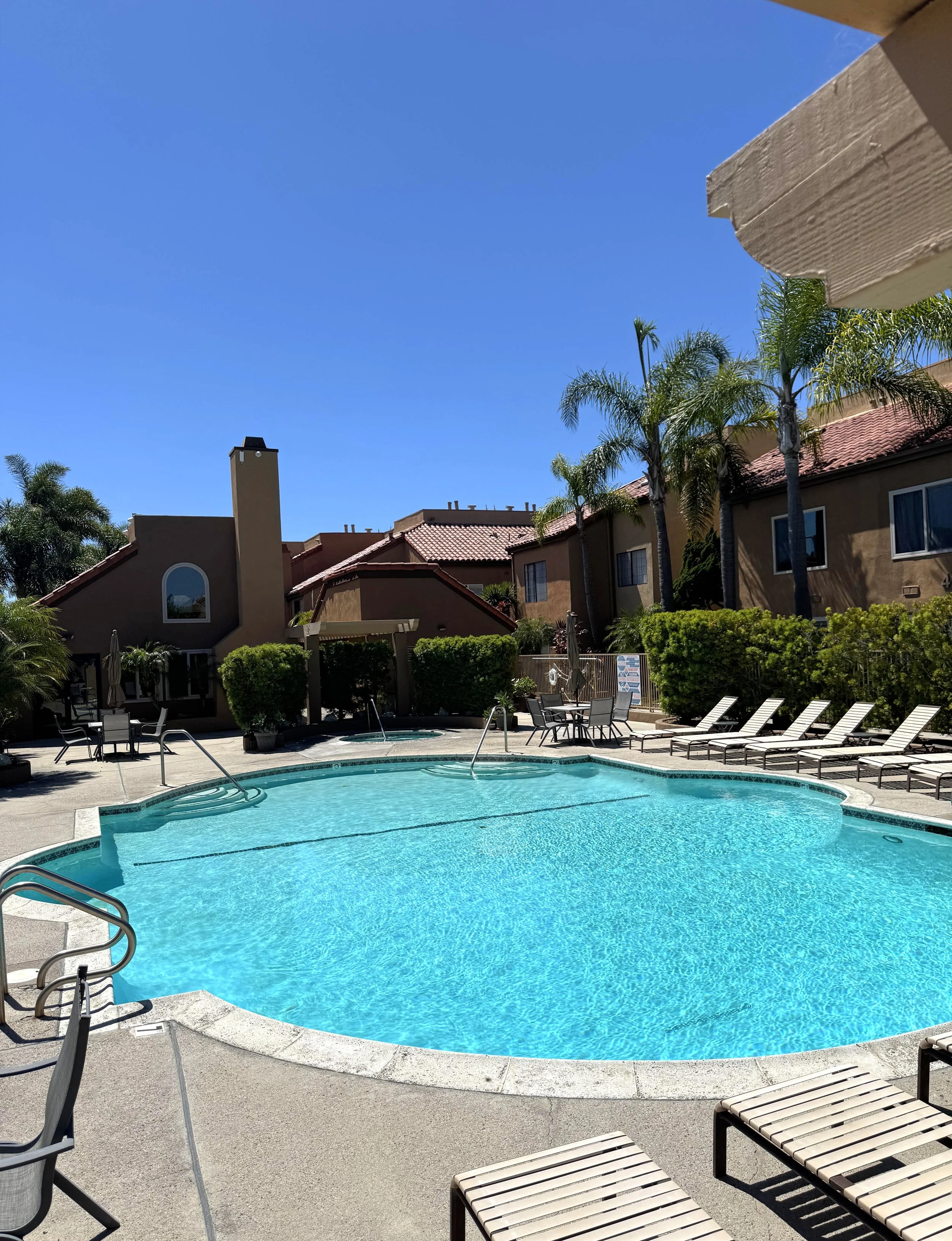 Villa St. Croix condos for sale in Huntington Beach featuring the swimming pool with the condos in the background.