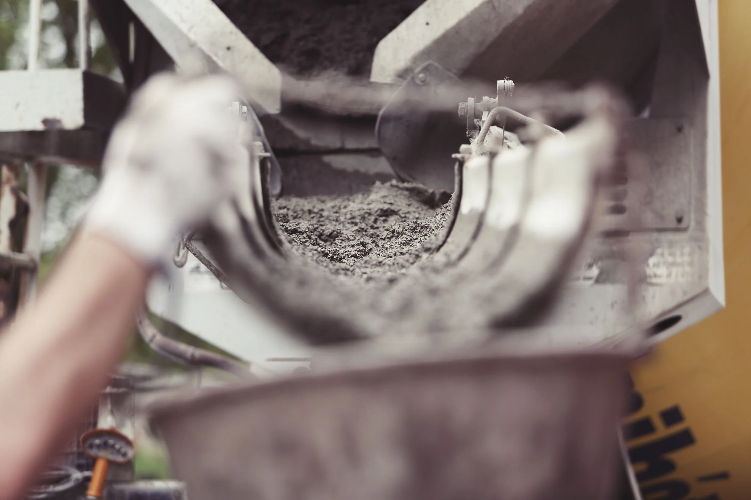 Close-up of a sandblasting or grinding process inside a metal machine or tool with dust and debris.