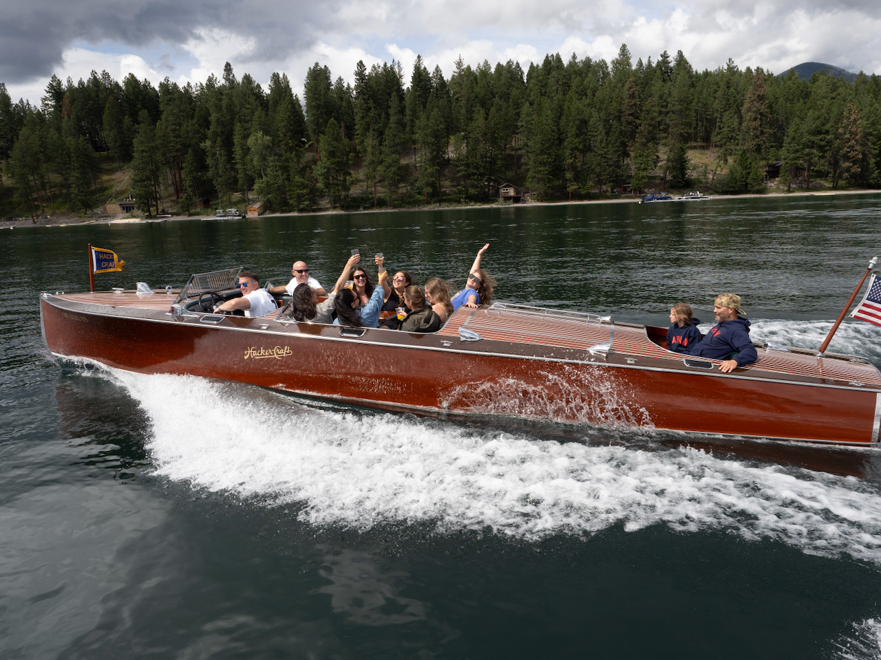 A private group of up to 10 guests experiencing an all-inclusive daytime boat charter on Whitefish Lake in Montana.