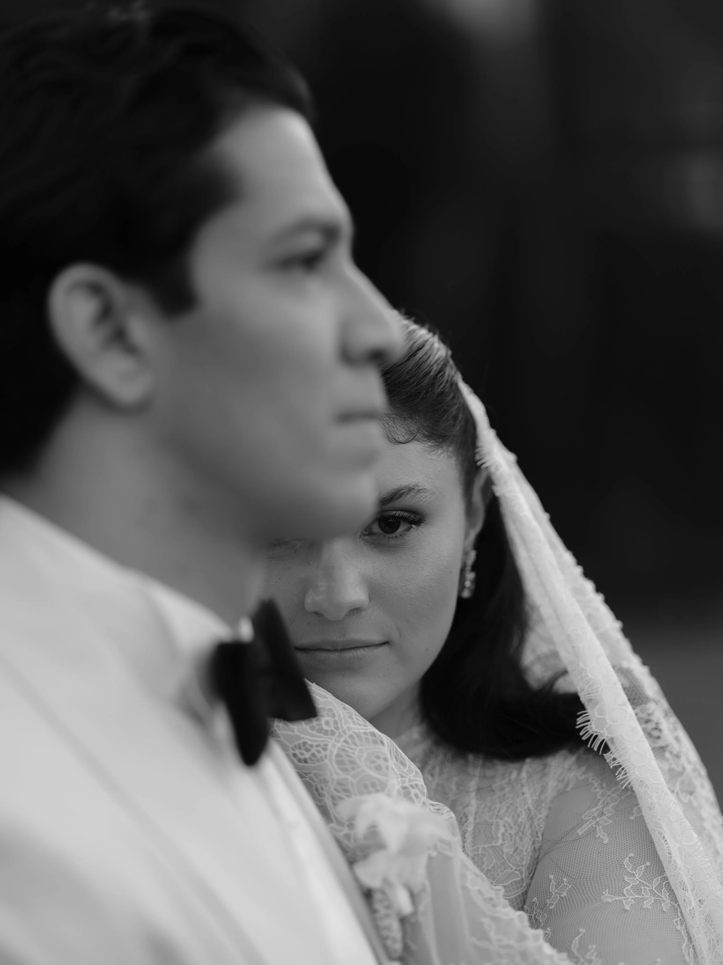 Pareja en una boda, ella con vestido de novia y él con traje, en una toma en blanco y negro.