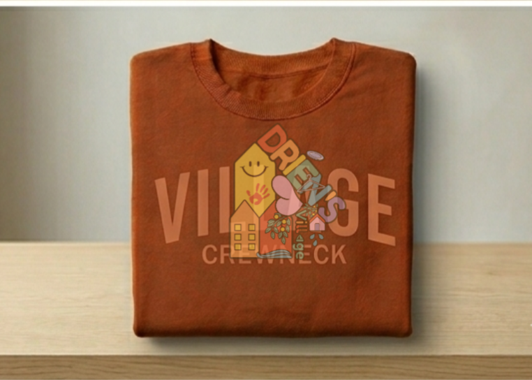An organic cotton crimson crewneck with a graphic design featuring a sun, house, flowers, and the words 'DRIEN'S VILLAGE'' printed on it.