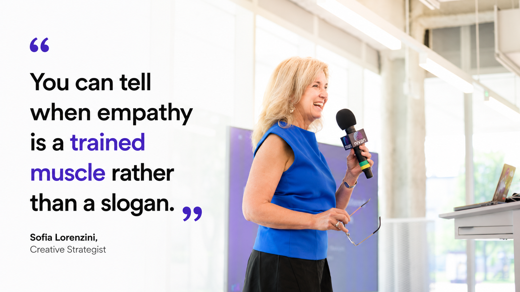 A woman in a blue dress holding a microphone and smiling during a presentation at Nivan The slide next to her displays a quote: 'You can tell when empathy is a trained muscle rather than a slogan,' attributed to Sofia Lorenzini, Creative Strategist.