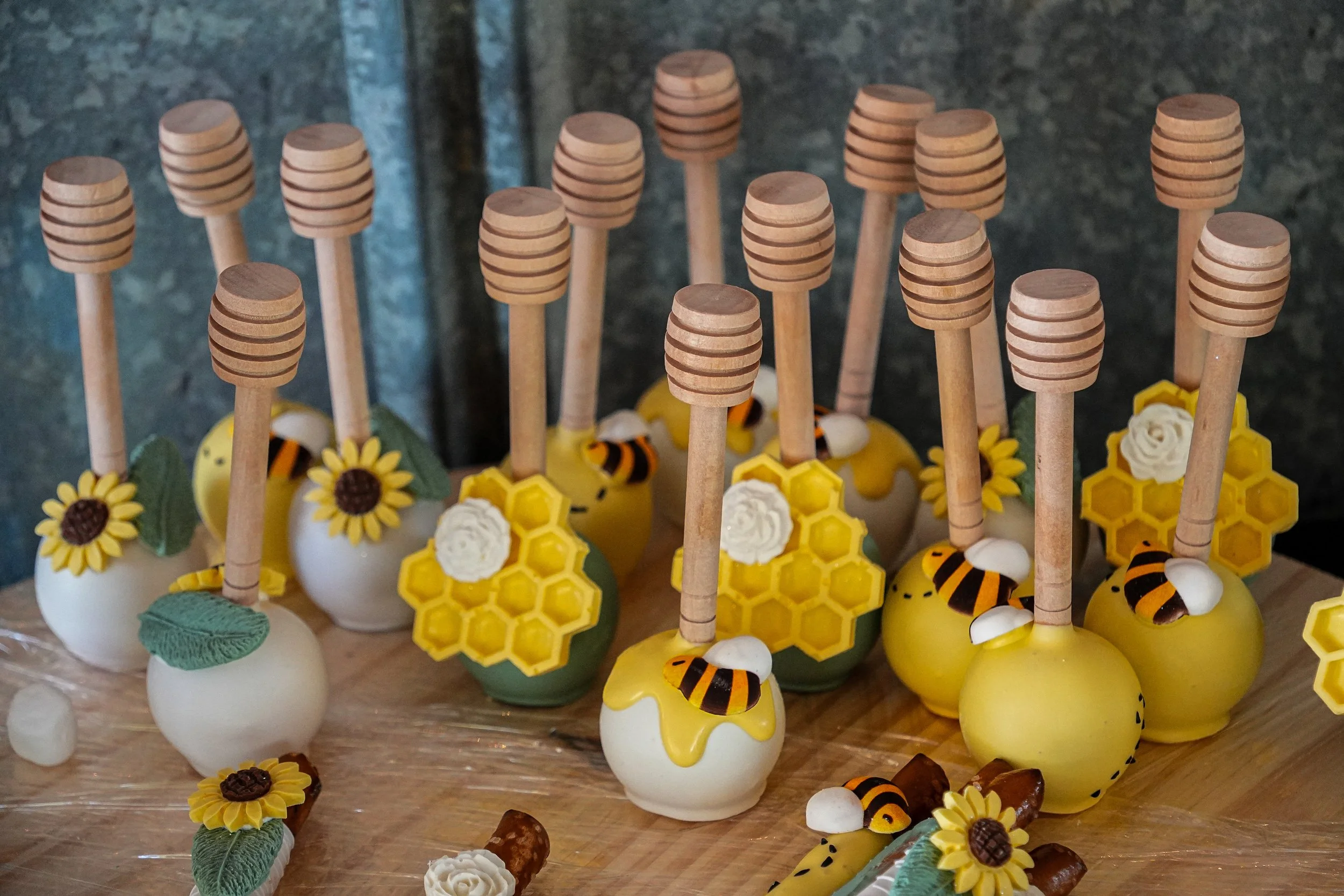 Assorted bee-themed decorative crafts including honey bee figures, sunflower decorations, honeycomb shapes, and wooden honey dipper sticks.