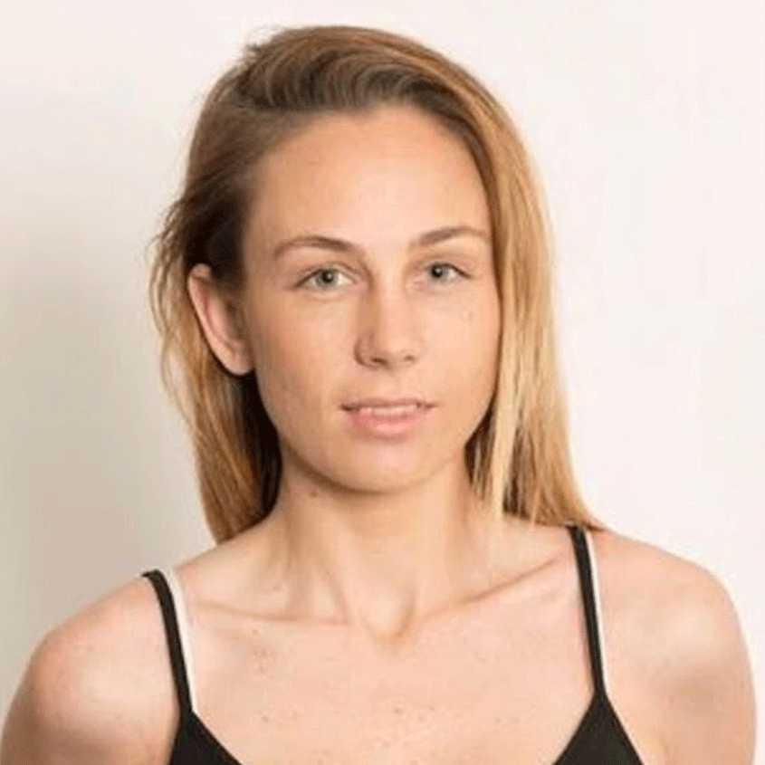 A woman with light brown hair, blue eyes, and fair skin looking at the camera, wearing a black spaghetti strap top, against a plain white background.