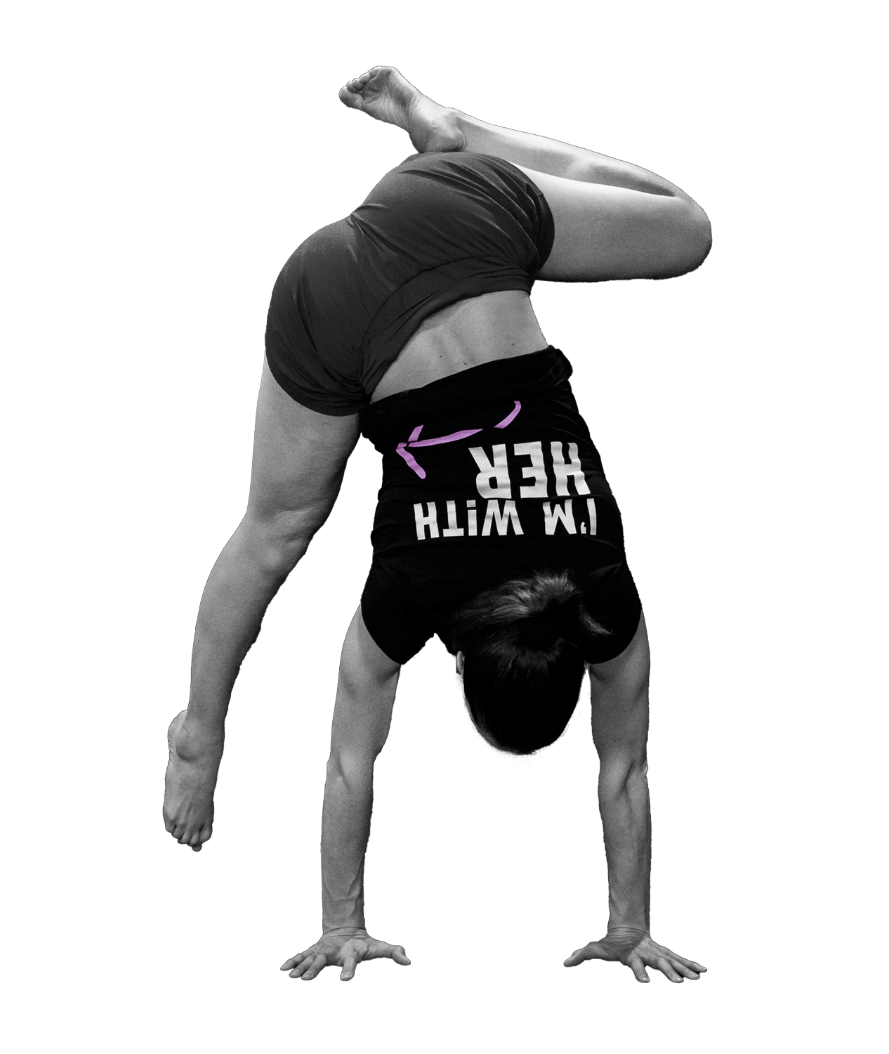 A person performing a handstand, with one leg bent and the other extended, wearing athletic clothing that says "I'M WITH HER" on the shirt.