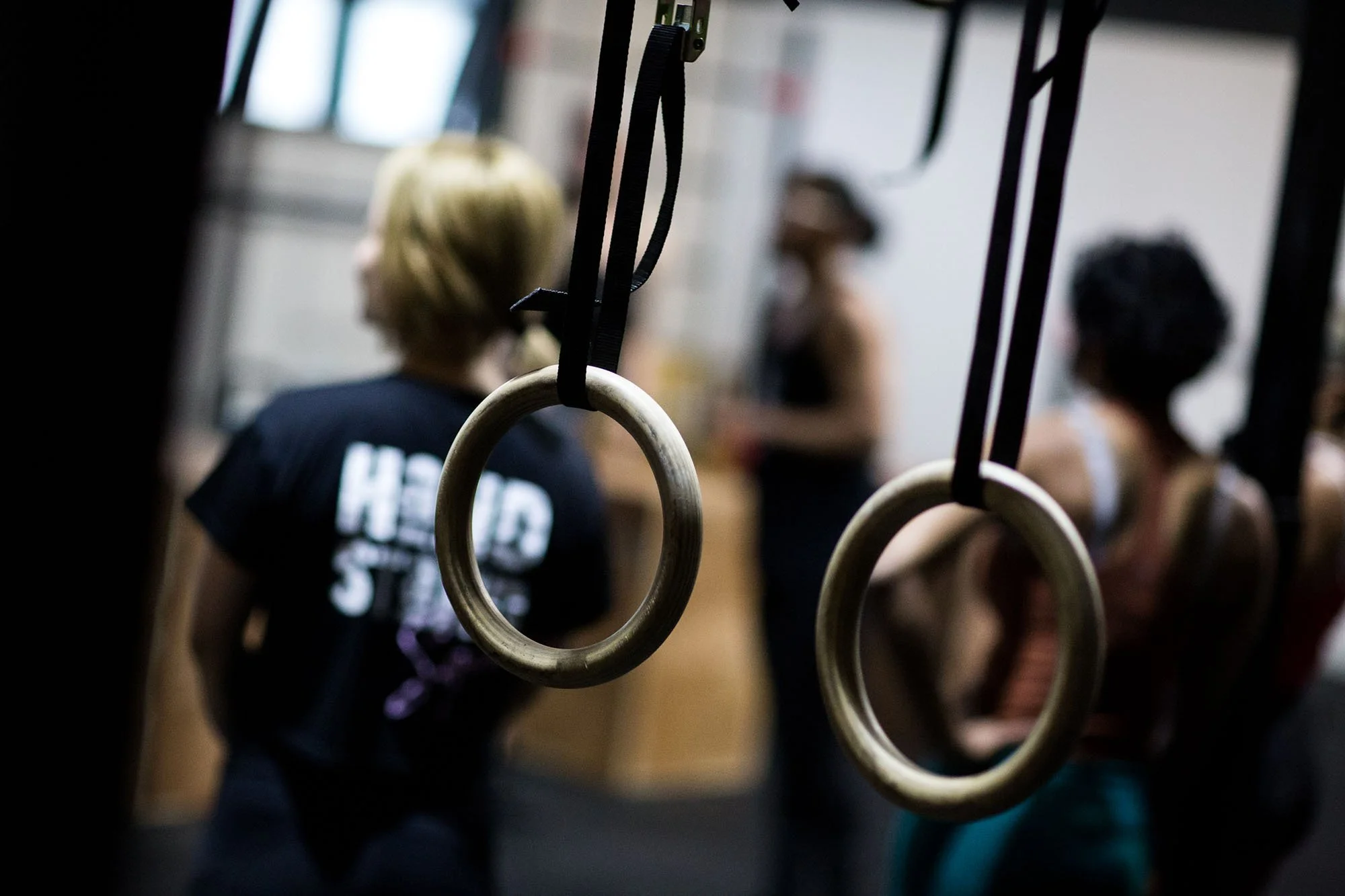 wooden gymnastic rings with women in distance