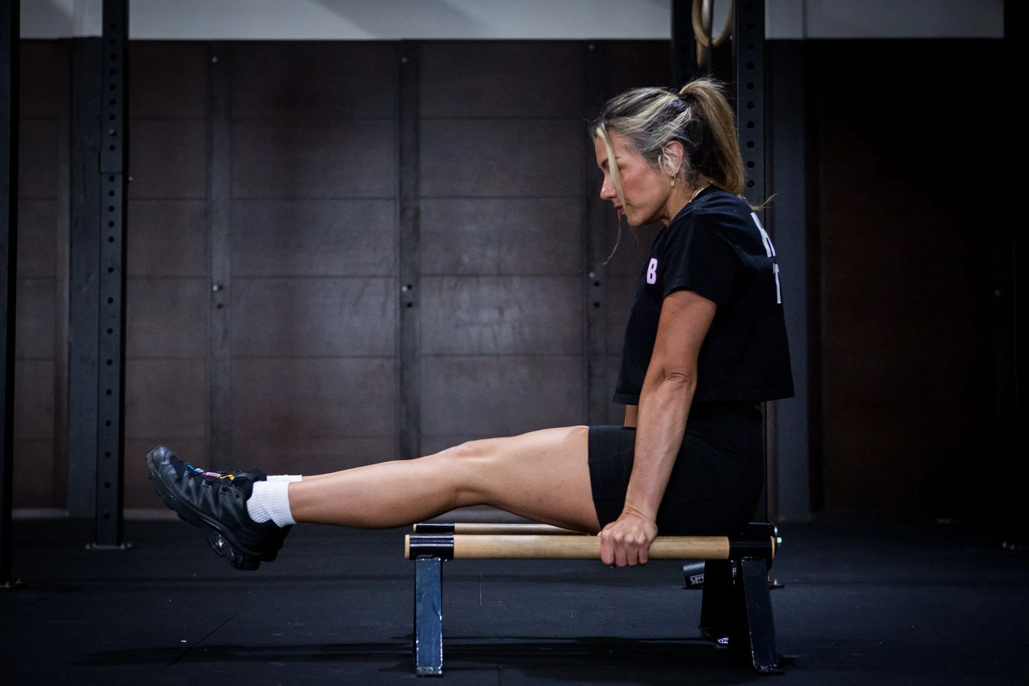 woman in an L-sit on parallette bars