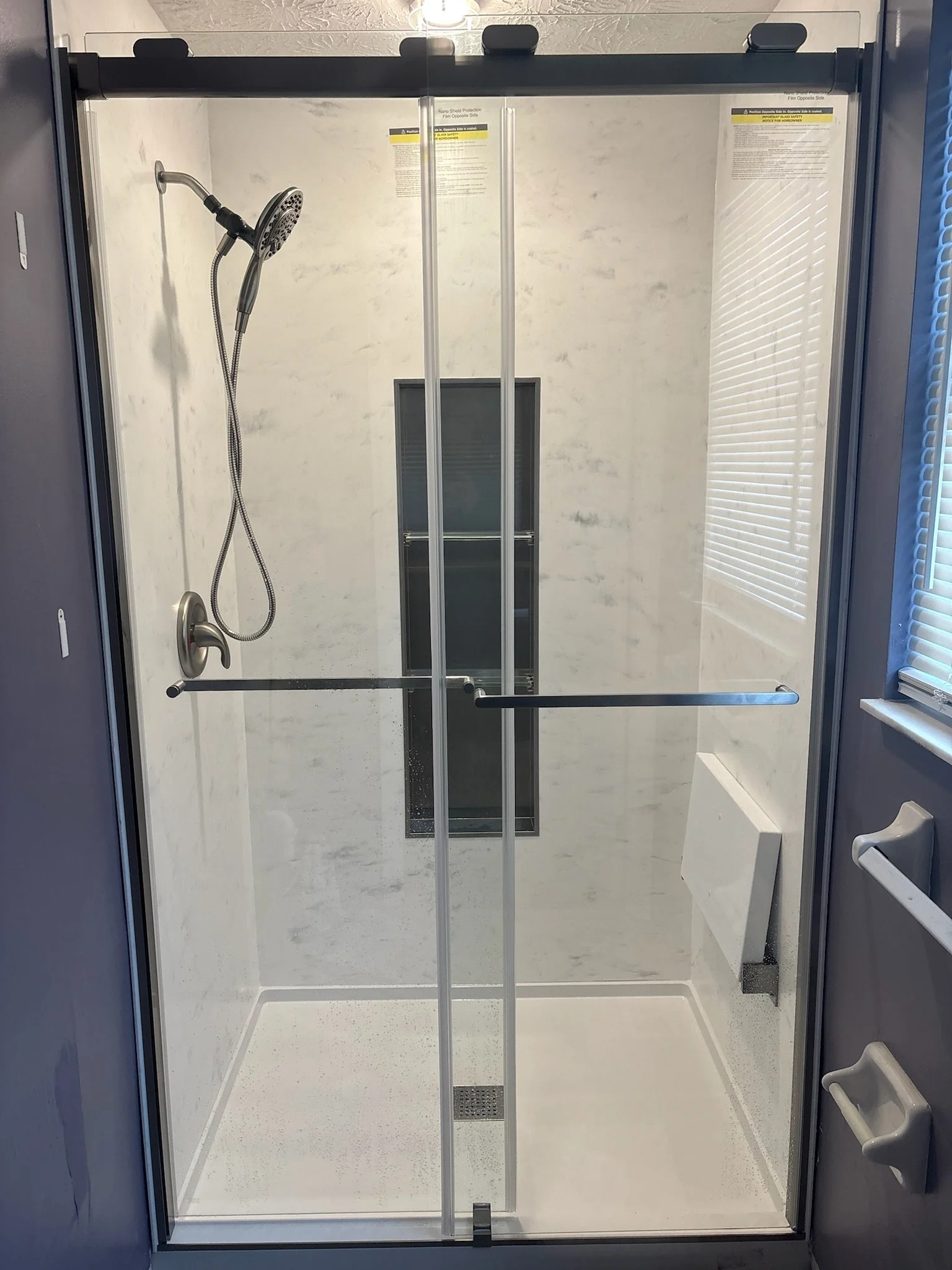 marble-walls-brushed-stainless-fixtures-sliding-glass-door-shower-niche-bench-lordstown-ohio.jpg