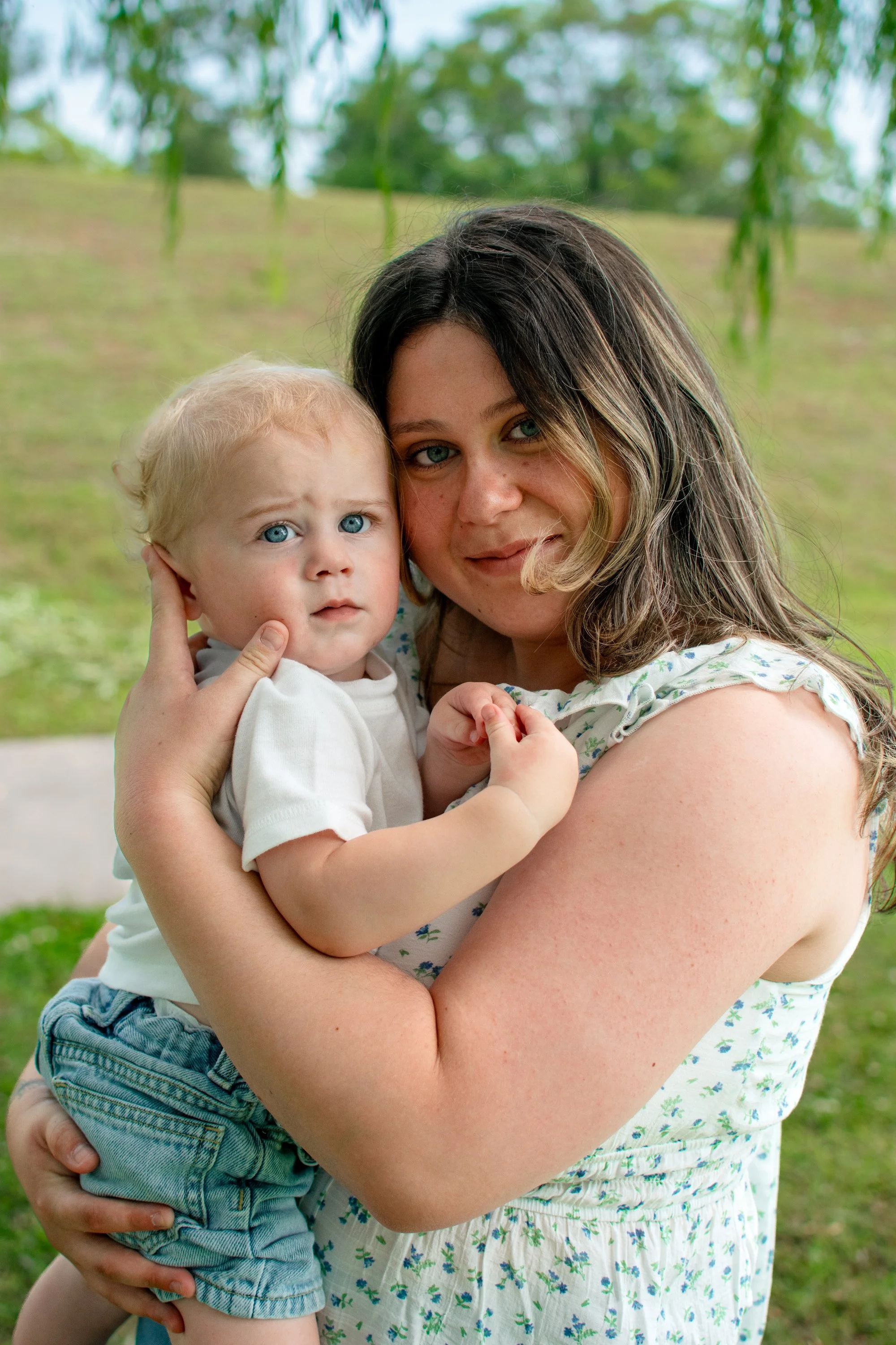 Mother holding her young son during a family photography session outdoors.