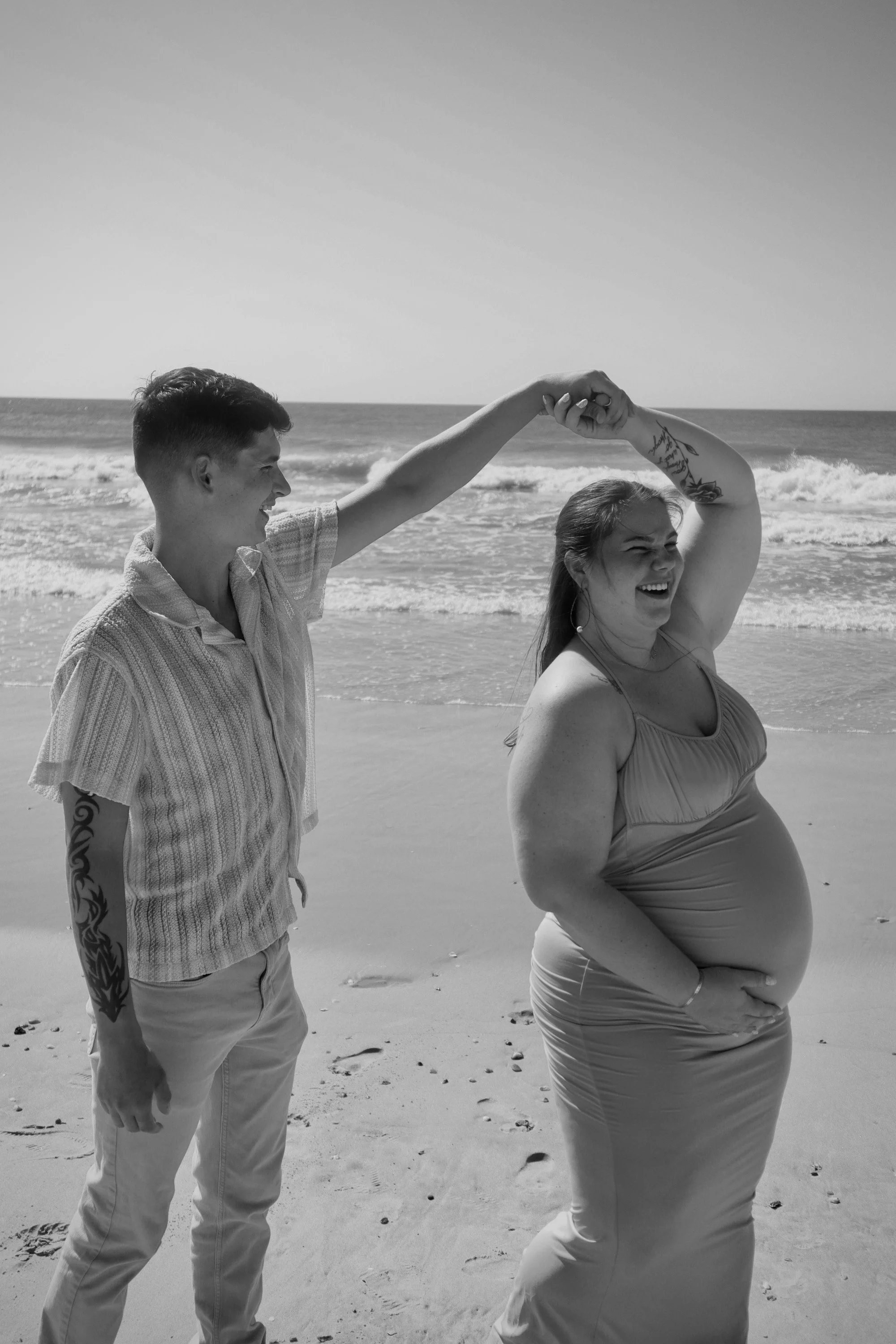 Expecting couple celebrating pregnancy during a beach maternity photography session