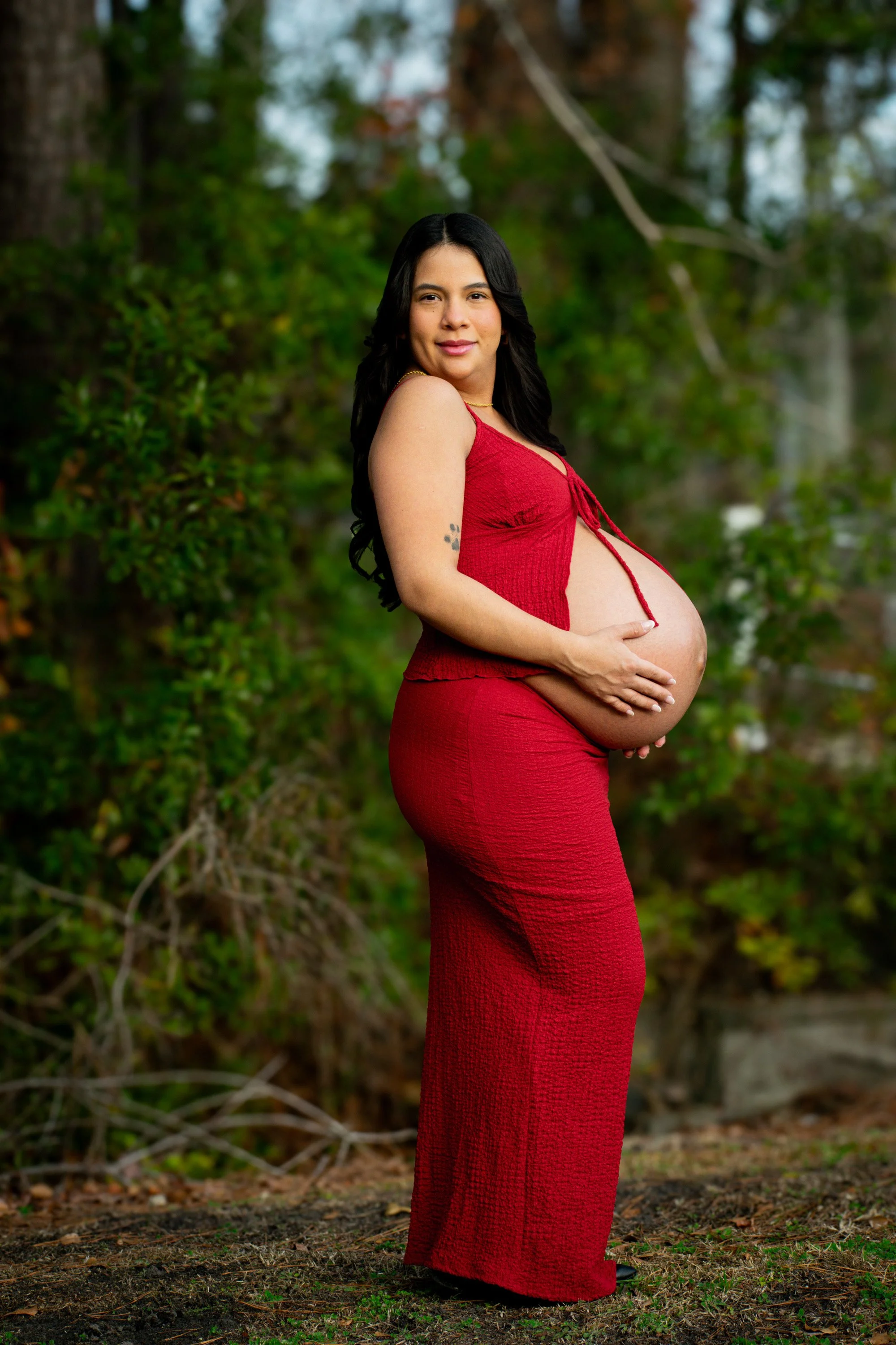 Close-up maternity portrait highlighting an expecting mother's baby bump outdoors.