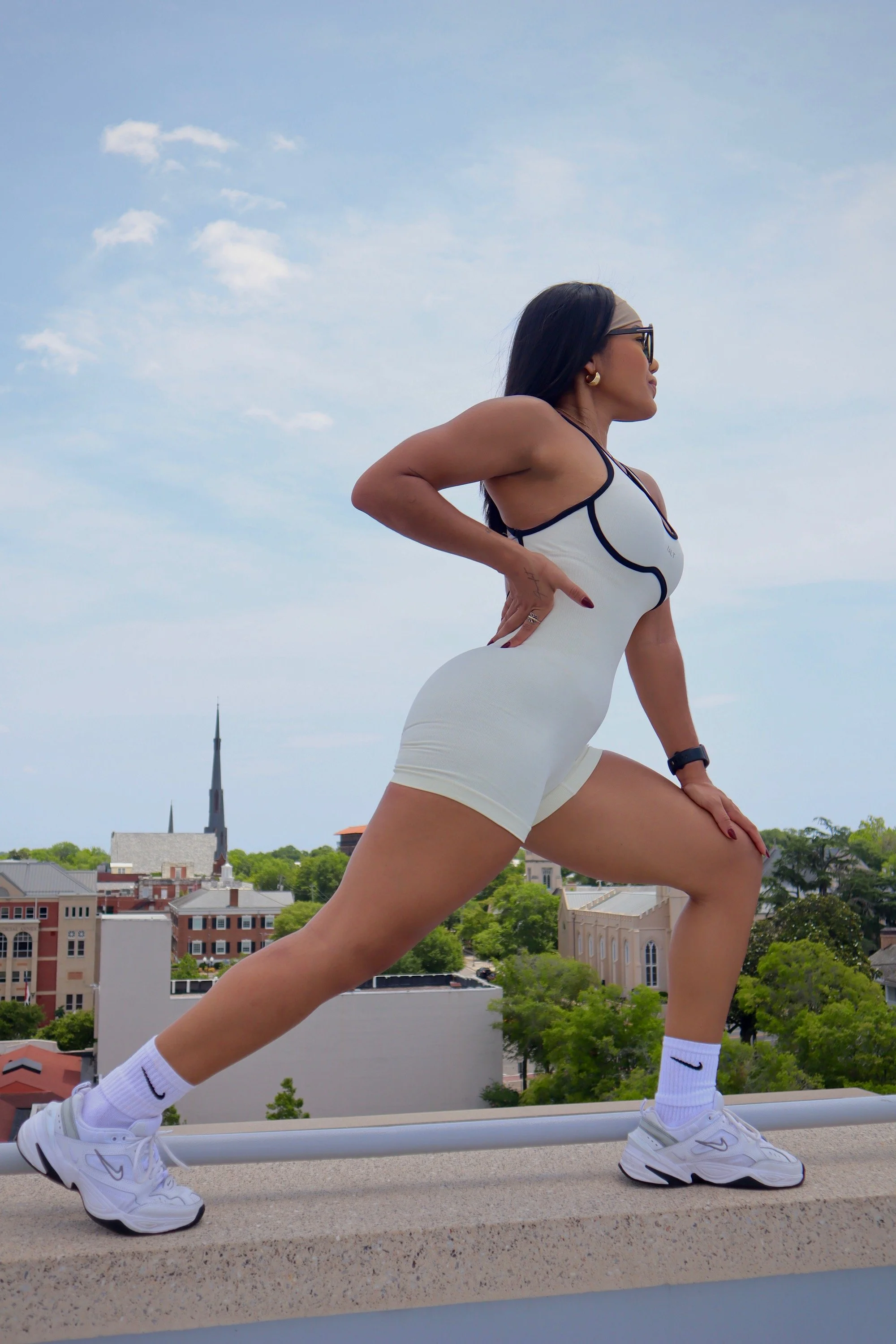 Fitness model stretching on a rooftop during a branding photography session