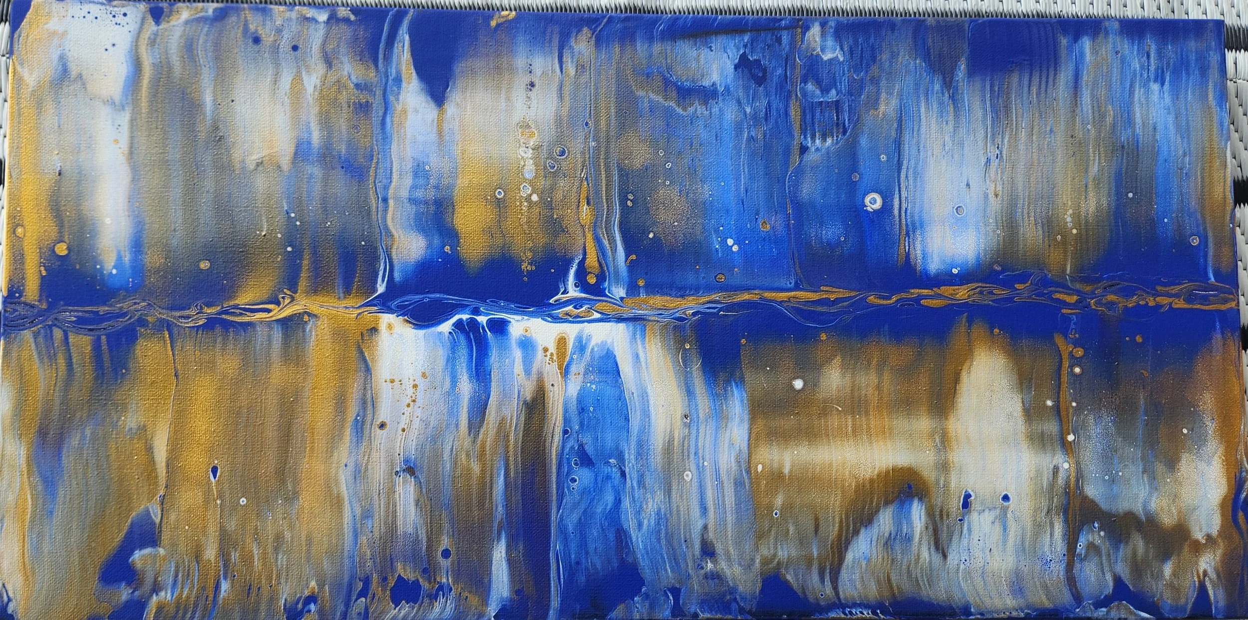 Abstract painting with blue, white, gold, and brown colors with flowing patterns and splatters.