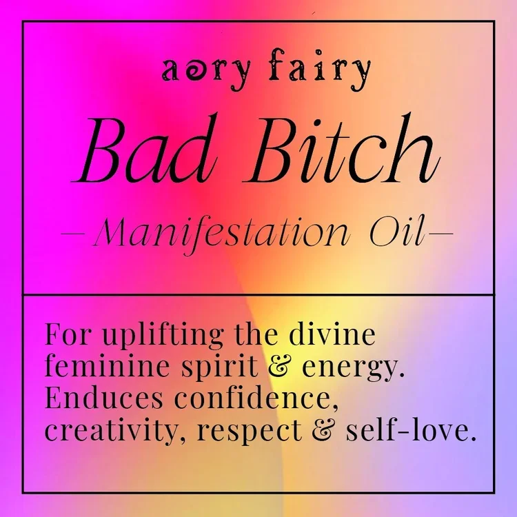 Label for 'Bad Bitch Manifestation Oil' with a rainbow gradient background, mentioning it uplifts divine feminine spirit and energy, and encourages confidence, creativity, respect, and self-love.