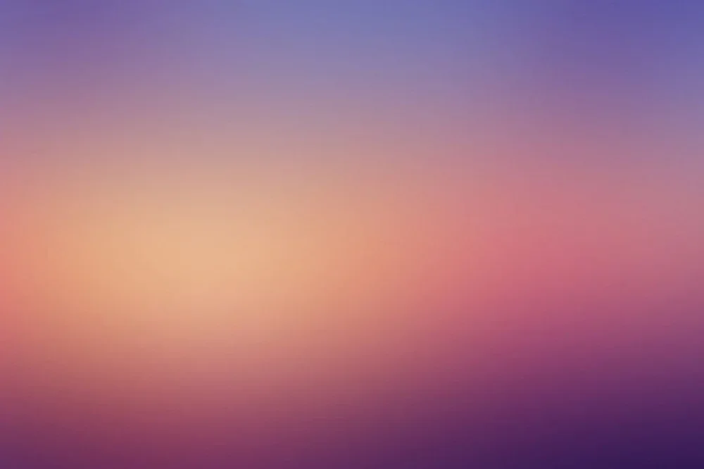 Blurred gradient sky during sunset or sunrise with pink, purple, and blue colors.