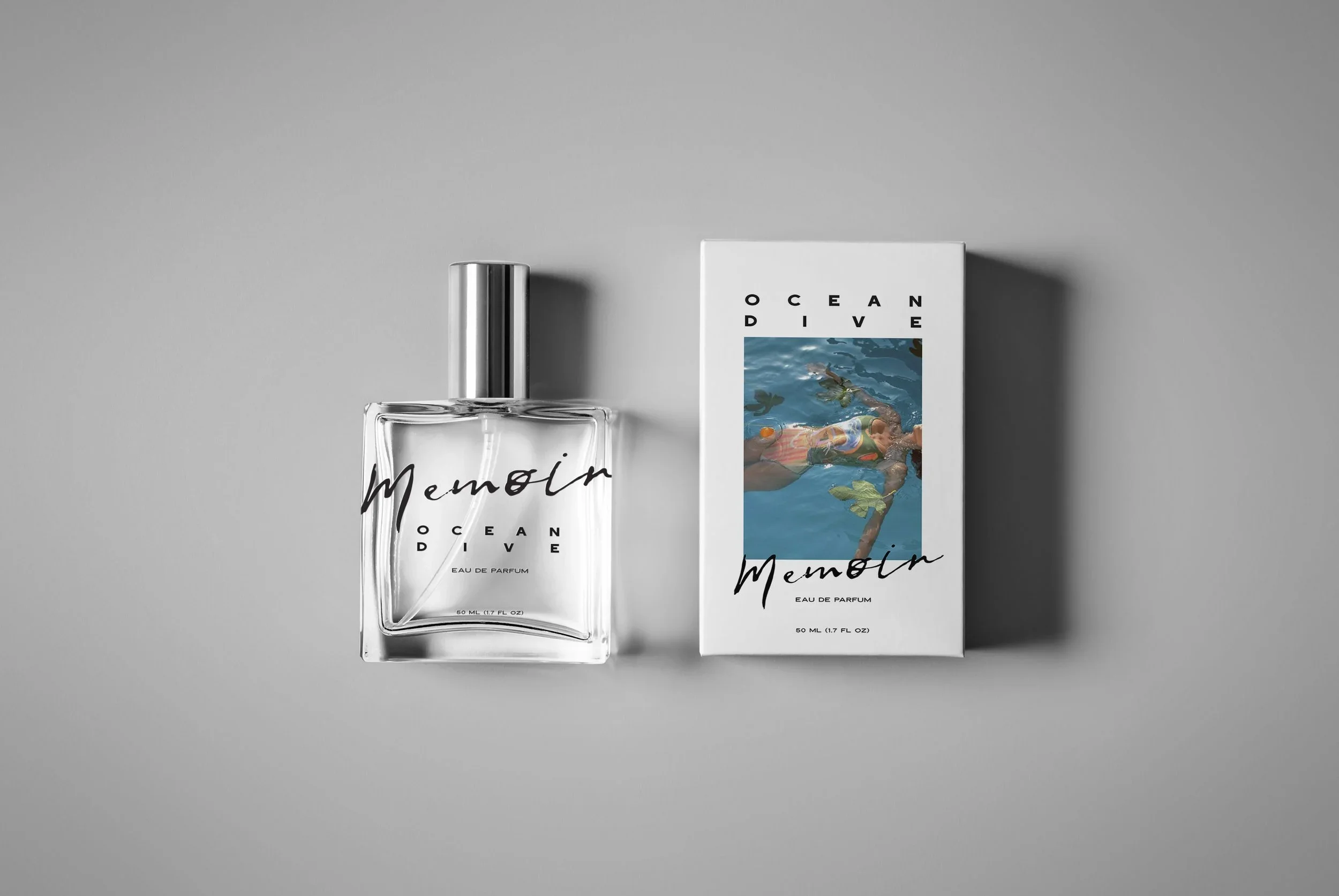 A clear perfume bottle labeled 'Memoin Ocean Dive' next to its white packaging box, which features an illustration of a person floating in water with leaves, against a plain gray background.