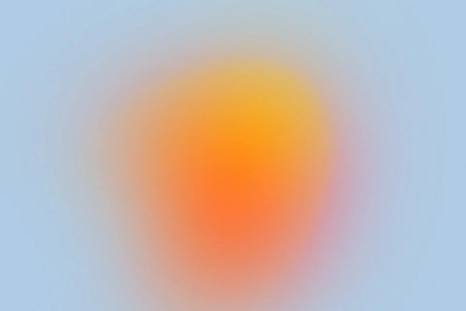 Blurred image with a bright central area and a gradient background, resembling a sunset or sunrise.