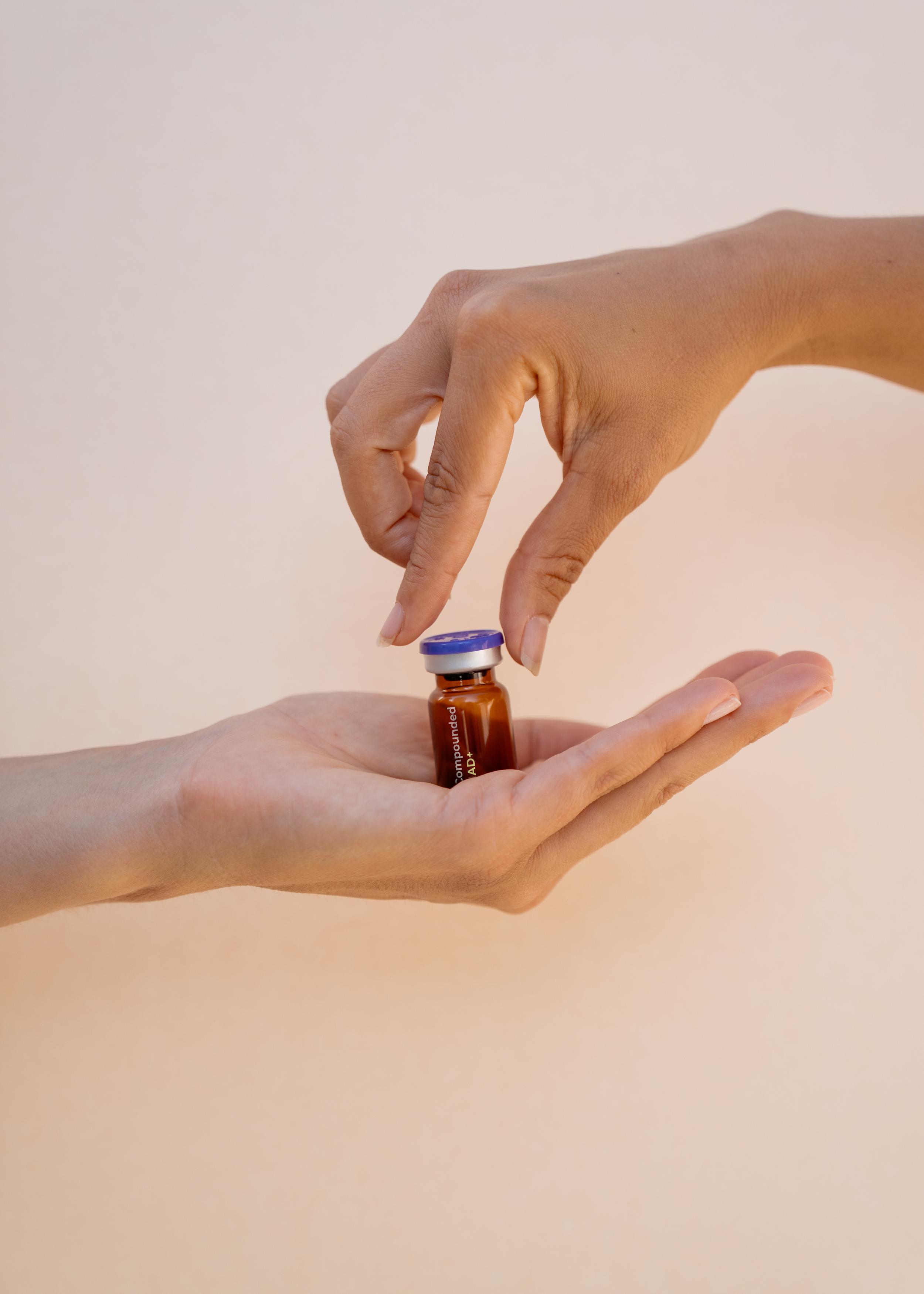 A person with light skin injecting a vaccine into another person's arm using a syringe and vial.
