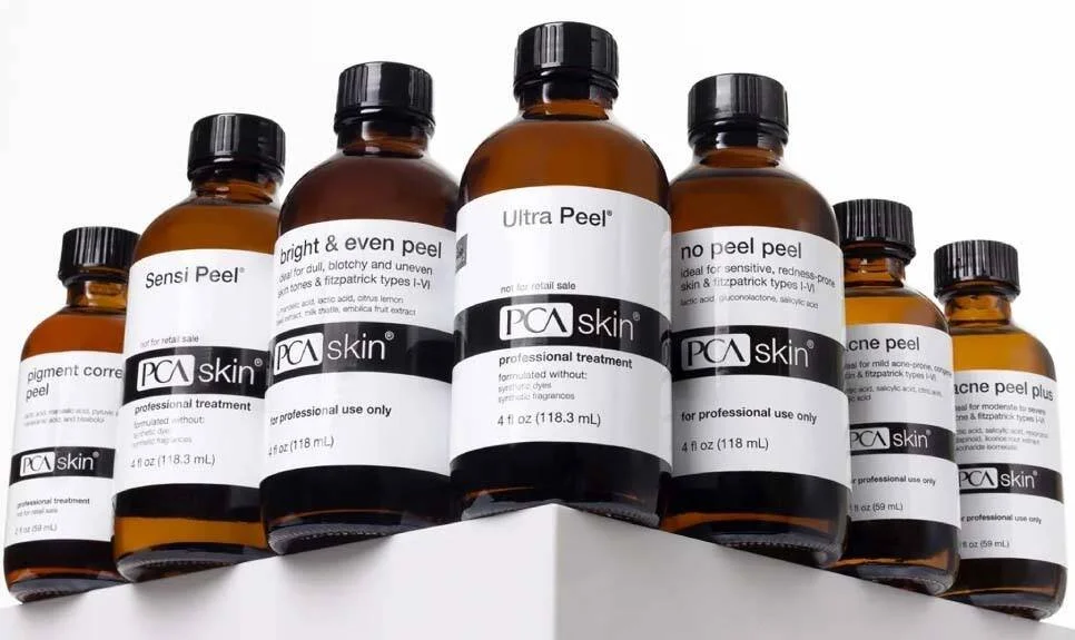 Collection of PCA Skin skincare bottles on a white shelf