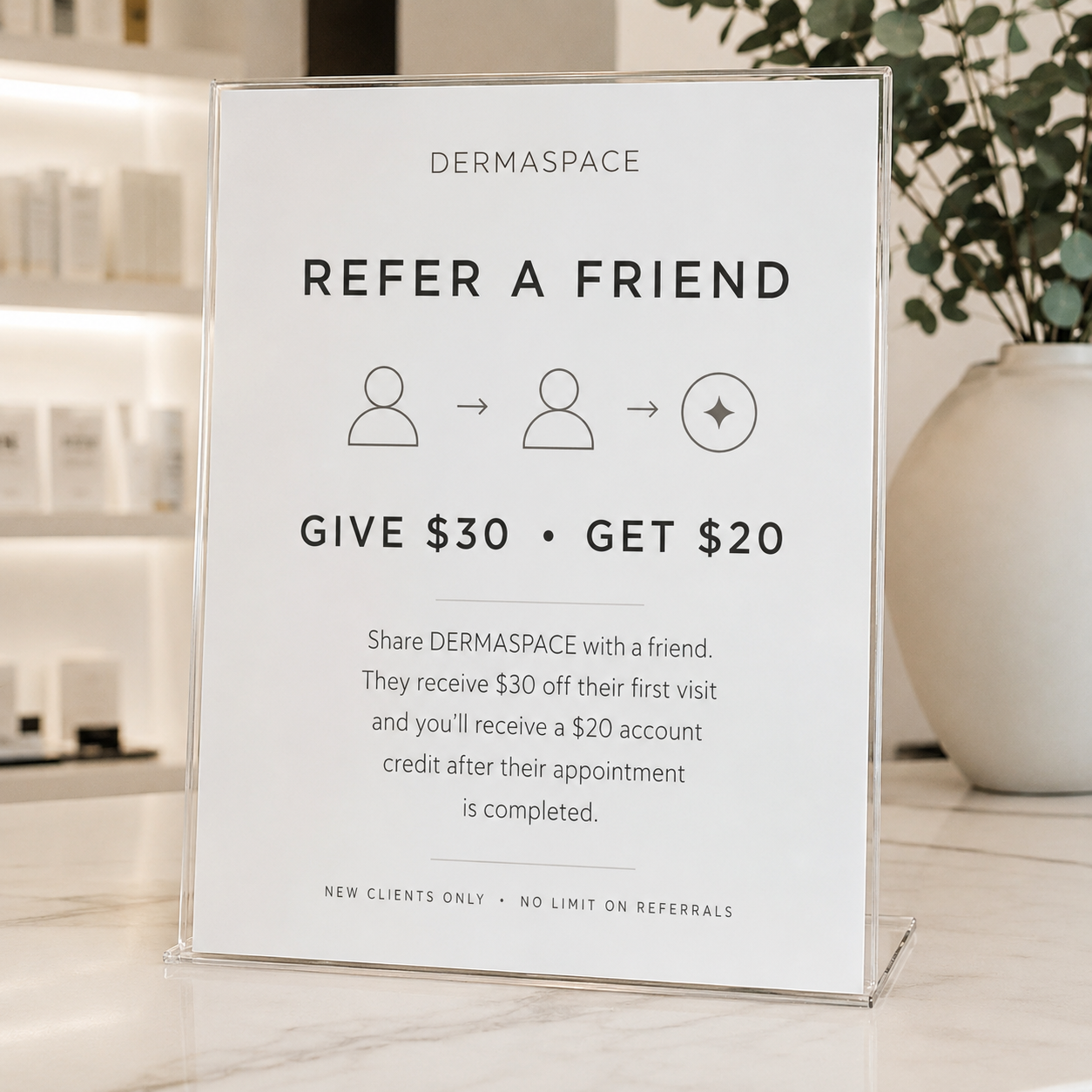 Sign promoting referral program at Dermaspace. Share Dermaspace with a friend to receive $30 off their first visit and get a $20 account credit after their appointment. Illustration shows two people and an arrow between them.