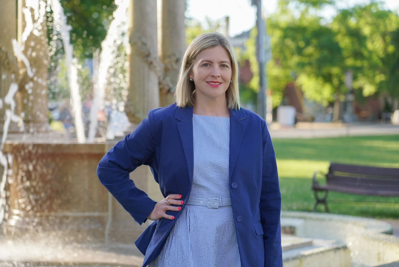 Chantelle smiling with hand on hip with a fountain behind her.