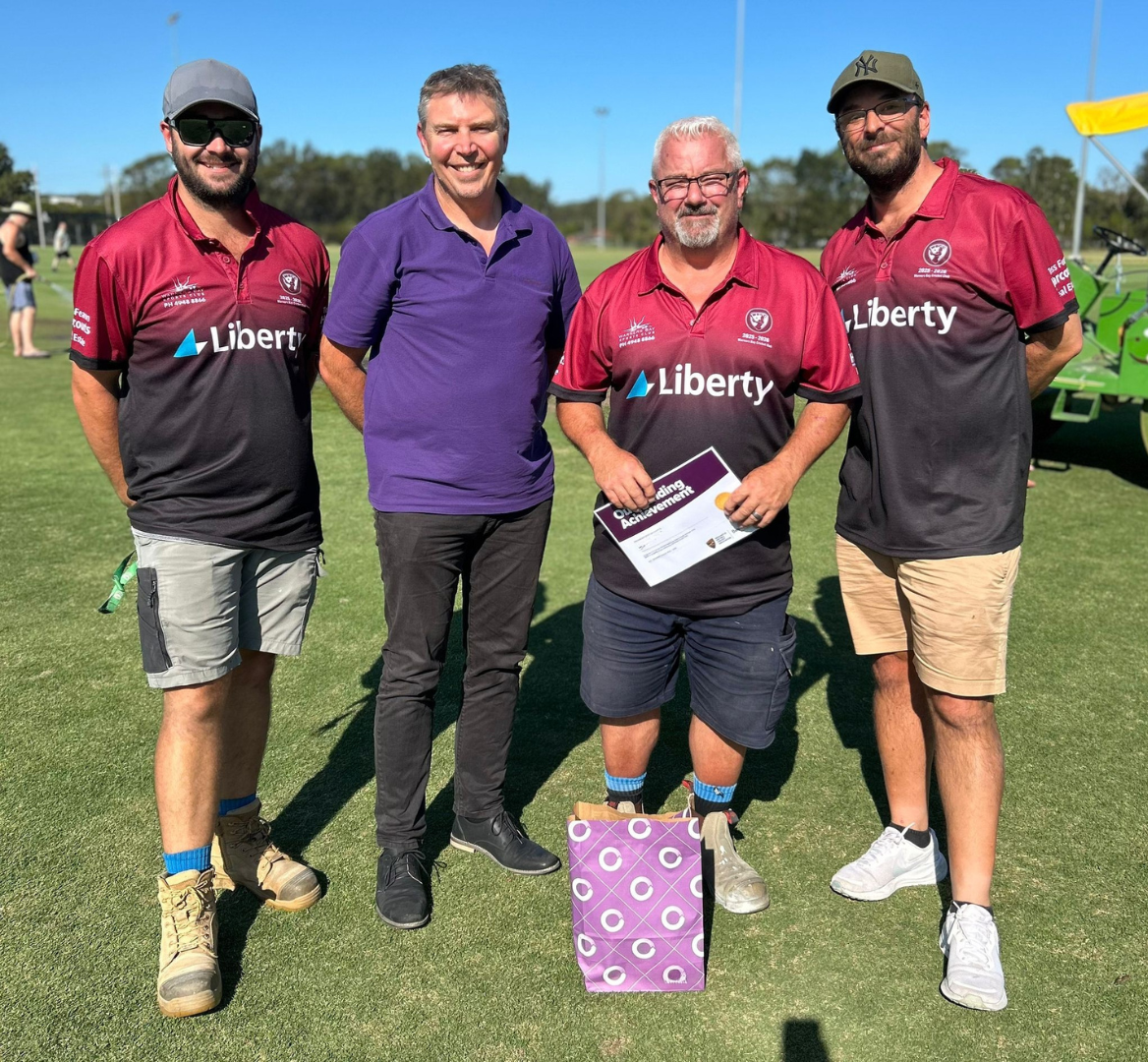 Four sports men standing on a grassy field, with Richard Stark, founder of The Fundraising Guy.