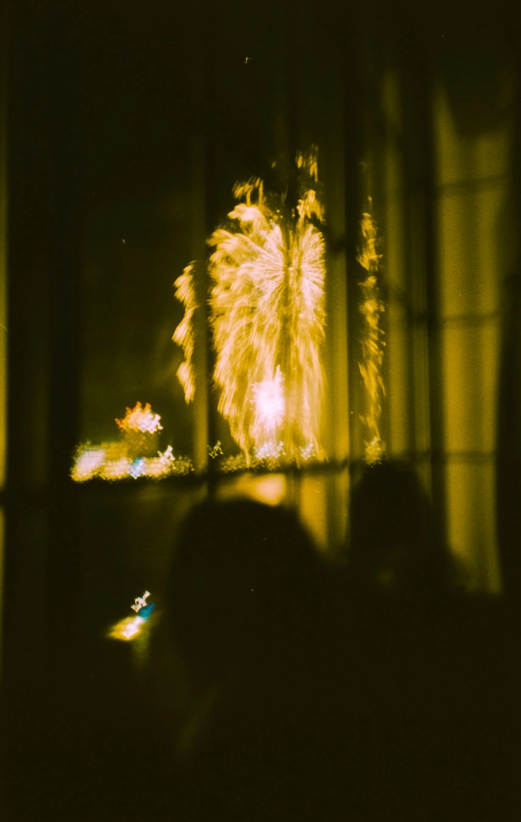 Fireworks display in the night sky with bright yellow and gold colors.